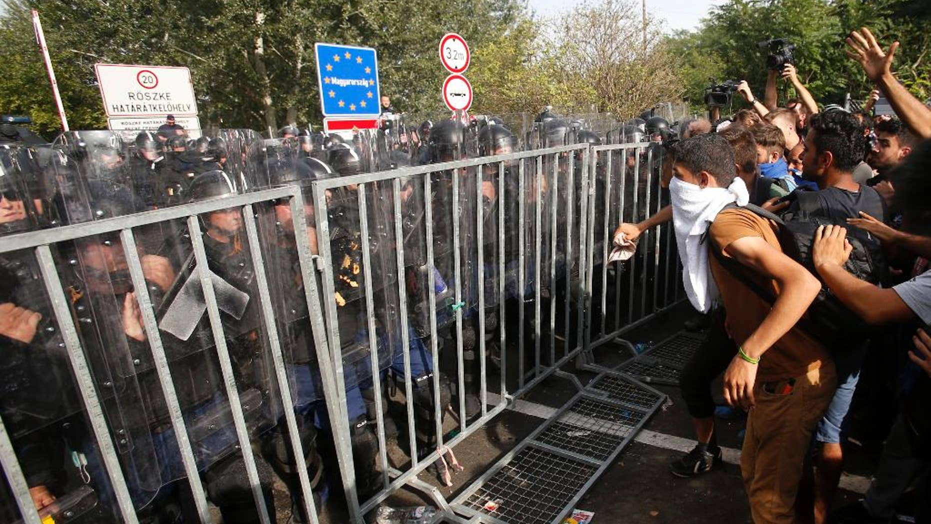 FILE- In this Sept. 16, 2016 file picture migrants protest at the "Horgos 2" border crossing into Hungary, near Horgos, Serbia. A Hungarian court Wednesday Nov. 30, 2016 has sentenced a Syrian man to 10 years in prison for taking part in a Sept. 2015 riot after Hungary closed its borders to migrants and refugees.Dozens of police officers, migrants and some journalists were injured in clashes on Sept. 16, 2015, a day after Hungary closed off its border with Serbia with a fence protected by razor wire, stranding hundreds of migrants. (AP Photo/Darko Vojinovic,file)