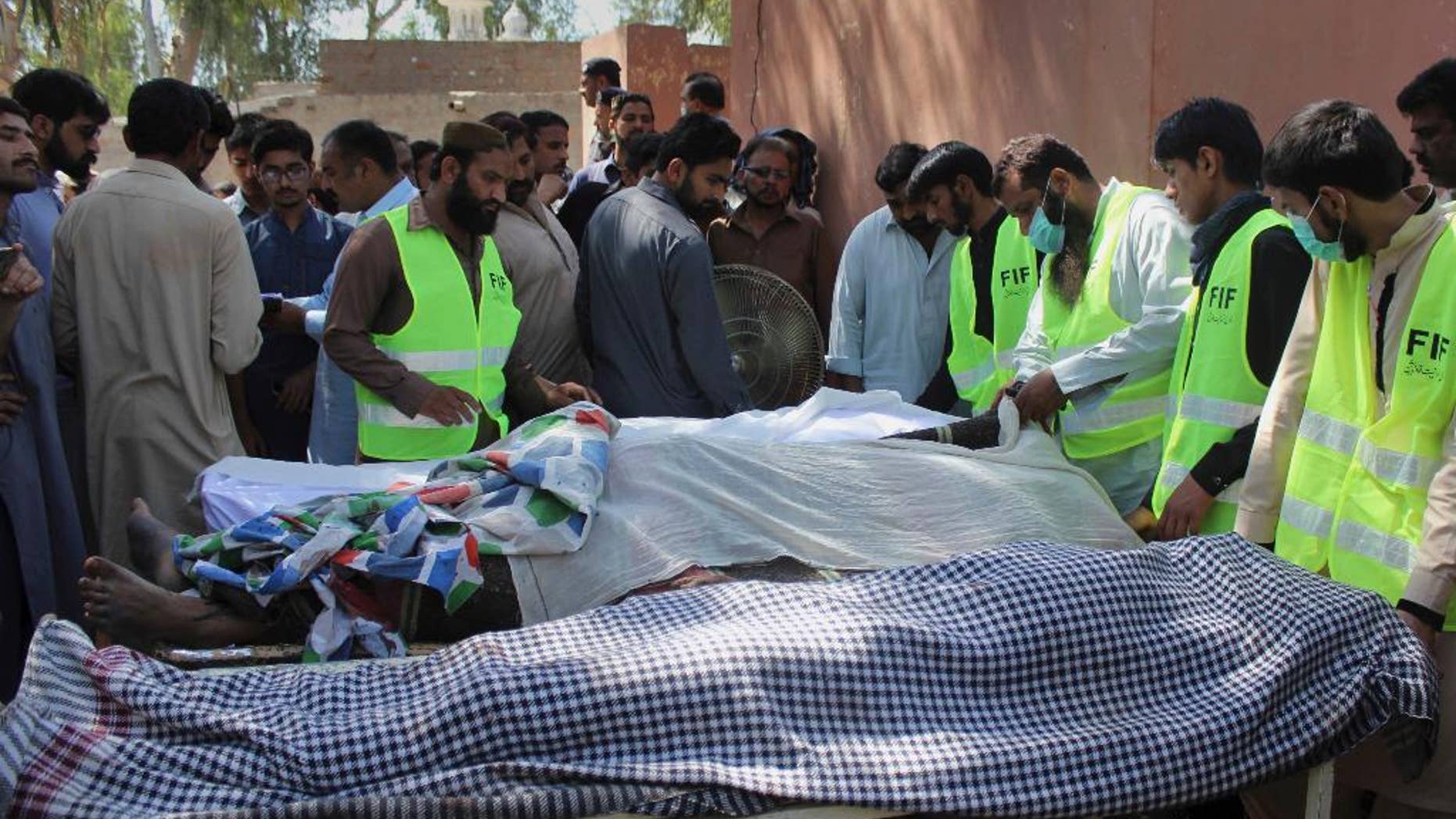 Pakistani volunteers and local residents gather around the bodies of people who were killed in a local shrine, outside the morgue of a hospital in Sarghodha, Pakistan, Sunday, April 2, 2017. Pakistani police say the custodian of the shrine and his accomplices have murdered 20 devotees in eastern Punjab province as part of a group cult ritual. (AP Photo/M.I. Haq)