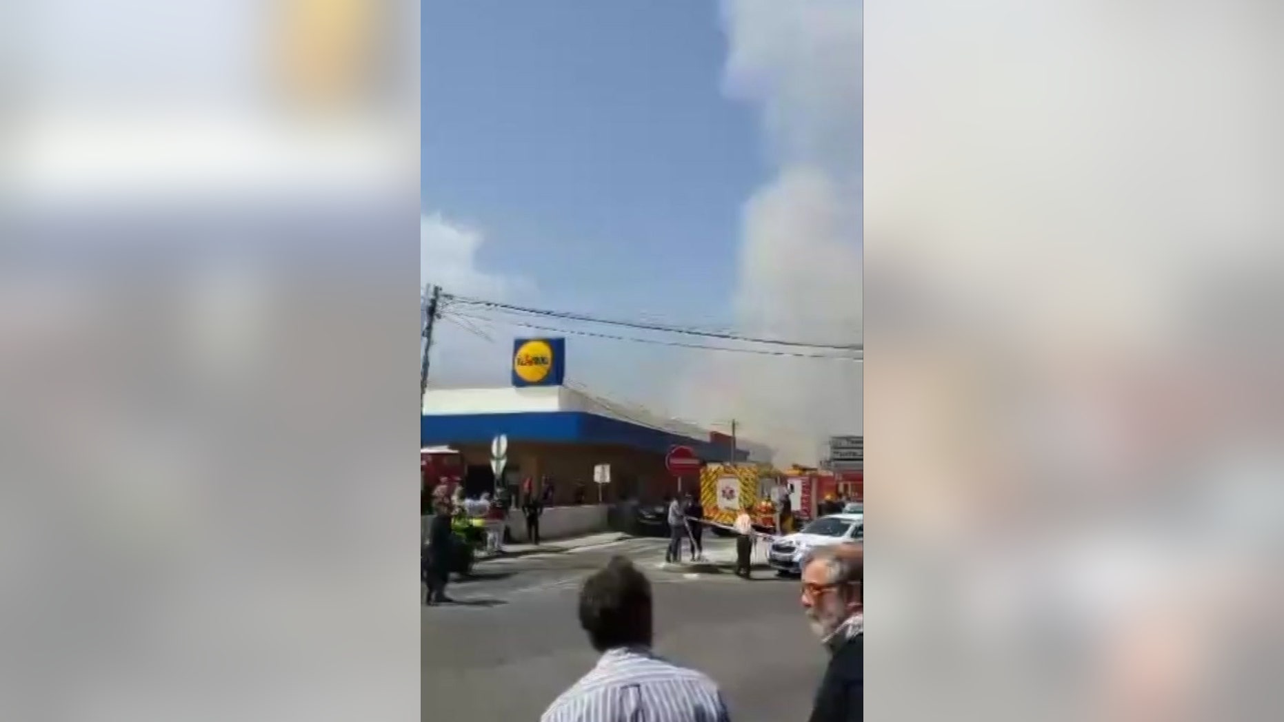 Smoke rises behind a supermarket near Lisbon after a small plane crashed. Portuguese officials say a small plane has crashed beside a supermarket near Lisbon, killing four people on board the aircraft and one on the ground. Four people were slightly injured. (Ramiro Ribeiro via AP)