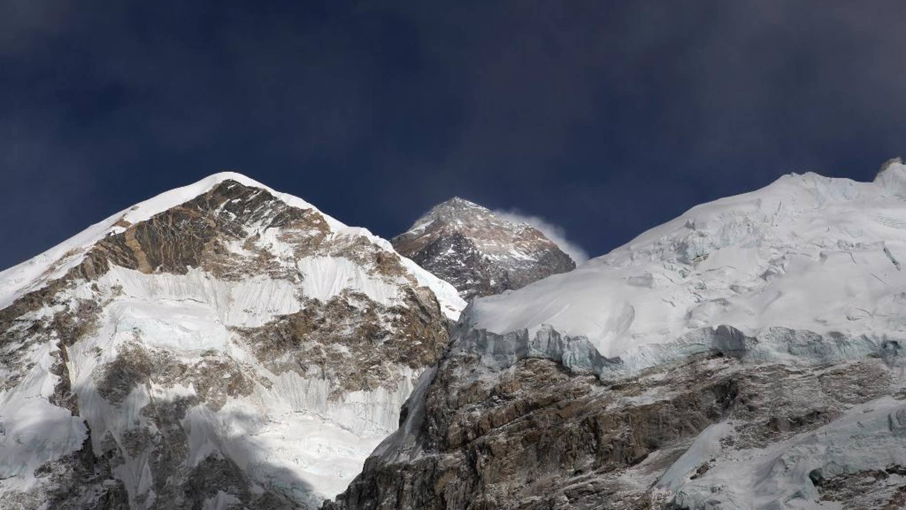 FILE - In this March 7, 2016 file photo, Mount Everest, in middle, altitude 8,848 meters (29,028 feet), is seen on the way to base camp. High winds have delayed dozens of climbers trying to reach the summit of Mount Everest, a mountaineer official said Wednesday, May 18, 2016. (AP Photo/Tashi Sherpa, File)