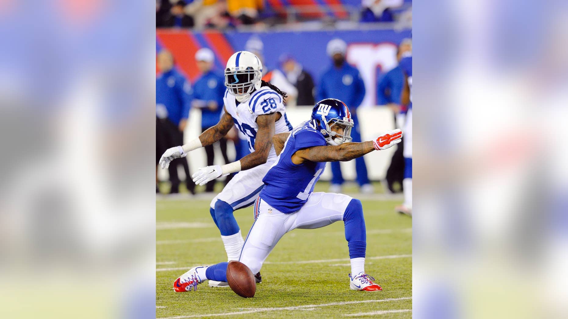 New York Giants' Odell Beckham, right, signals a first down after making a catch in front of Indianapolis Colts' Greg Toler (28) during the first half of an NFL football game Monday, Nov. 3, 2014, in East Rutherford, N.J. (AP Photo/Bill Kostroun)