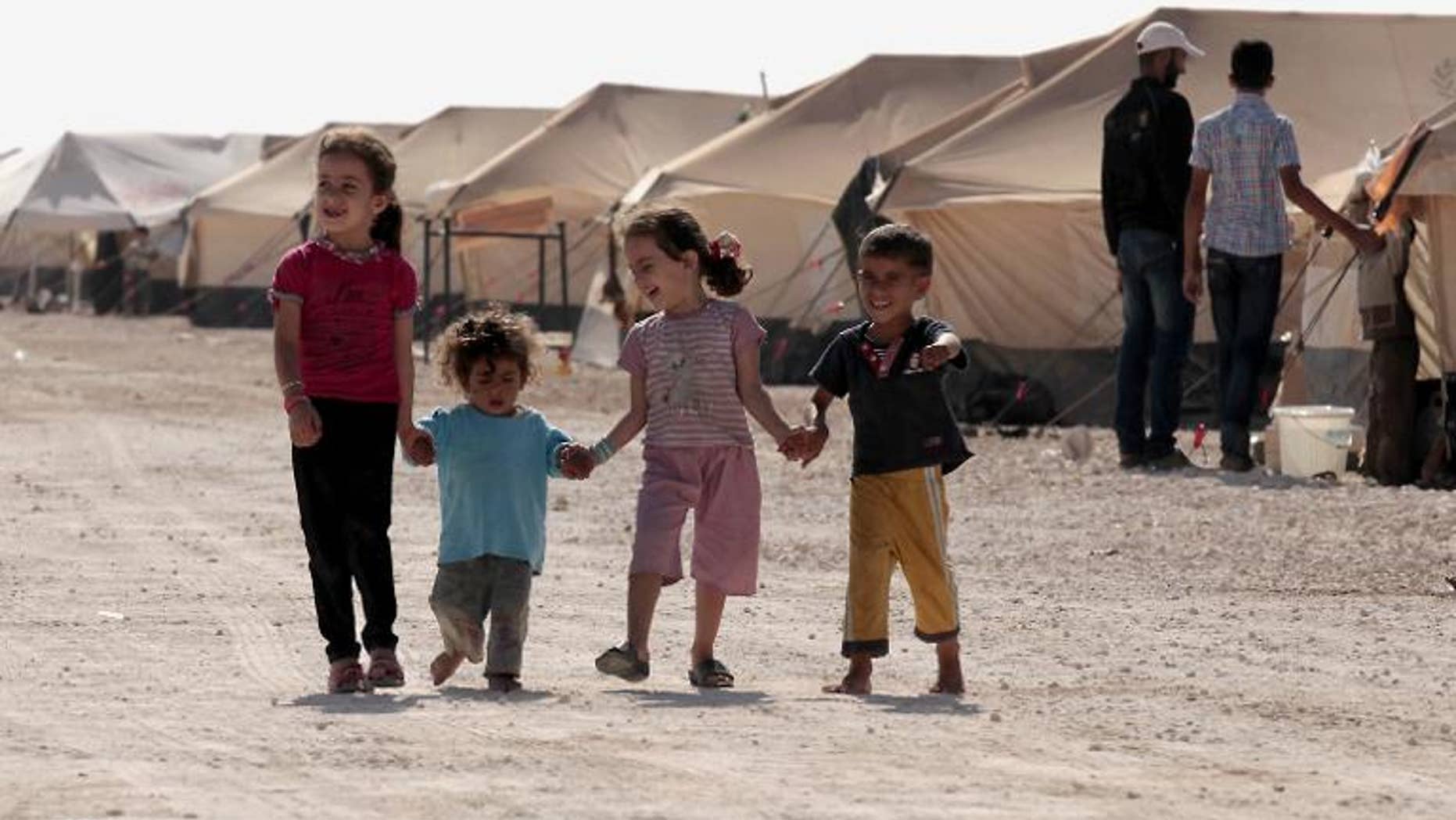 Syrian refugee children walk amid tents at the Zaatri refugee camp, near the Jordanian border with Syria, on September 11, 2012