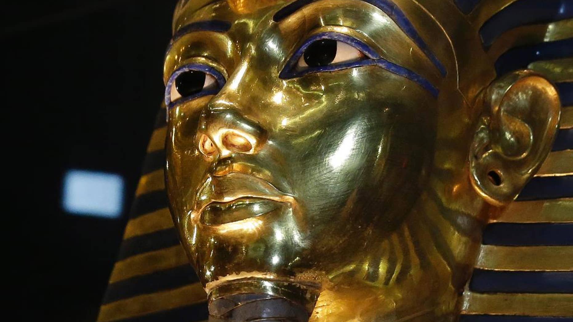 FILE - In this Saturday, Jan. 24, 2015, file photo, the gold mask of King Tutankhamun is seen in its glass case during a press tour, in the Egyptian Museum near Tahrir Square, Cairo, Egypt. The restoration of King Tutankhamun's world-famous golden mask will begin Saturday, over a year after the beard was accidentally broken off and hastily glued back with epoxy, Egypt's state-run news agency said Friday. (AP Photo/Hassan Ammar, File)