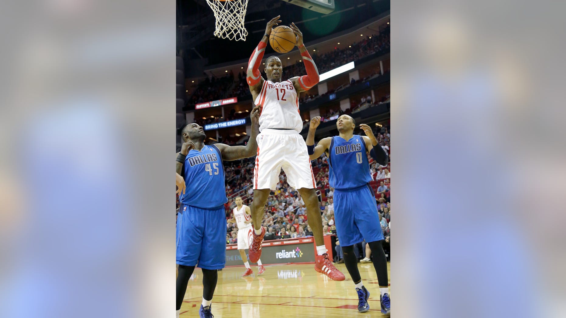 Houston Rockets' Dwight Howard (12) grabs a rebound between Dallas Mavericks Samuel Dalembert (1) and DeJuan Blair (45) in the first half of an NBA basketball game Friday, Nov. 1, 2013, in Houston. (AP Photo/Pat Sullivan)