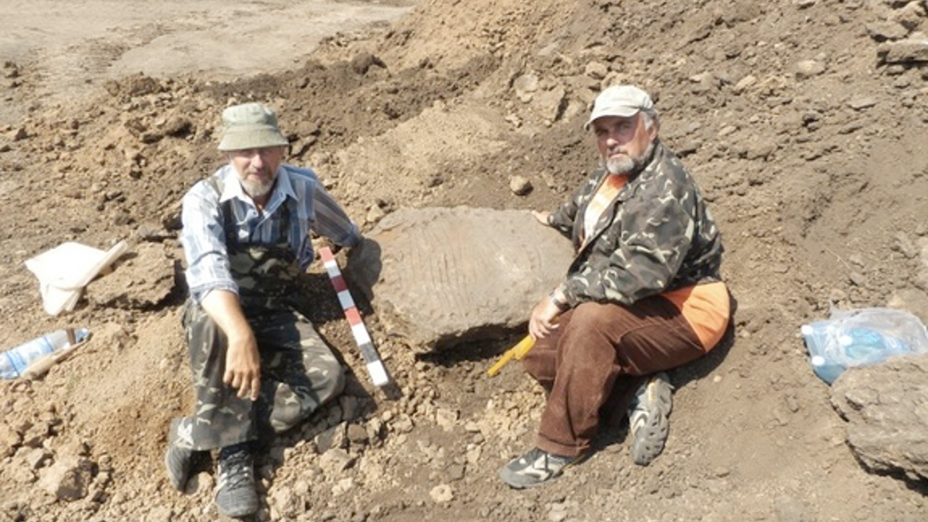 Archaeologists pose with a Bronze Age sundial dating back more than 3,000 years.
