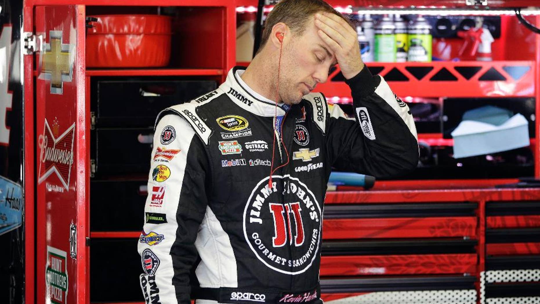 Kevin Harvick wipes his head during a practice session for Sunday's NASCAR Pocono 400 auto race, Saturday, Aug. 1, 2015, in Long Pond, Pa. (AP Photo/Matt Slocum)