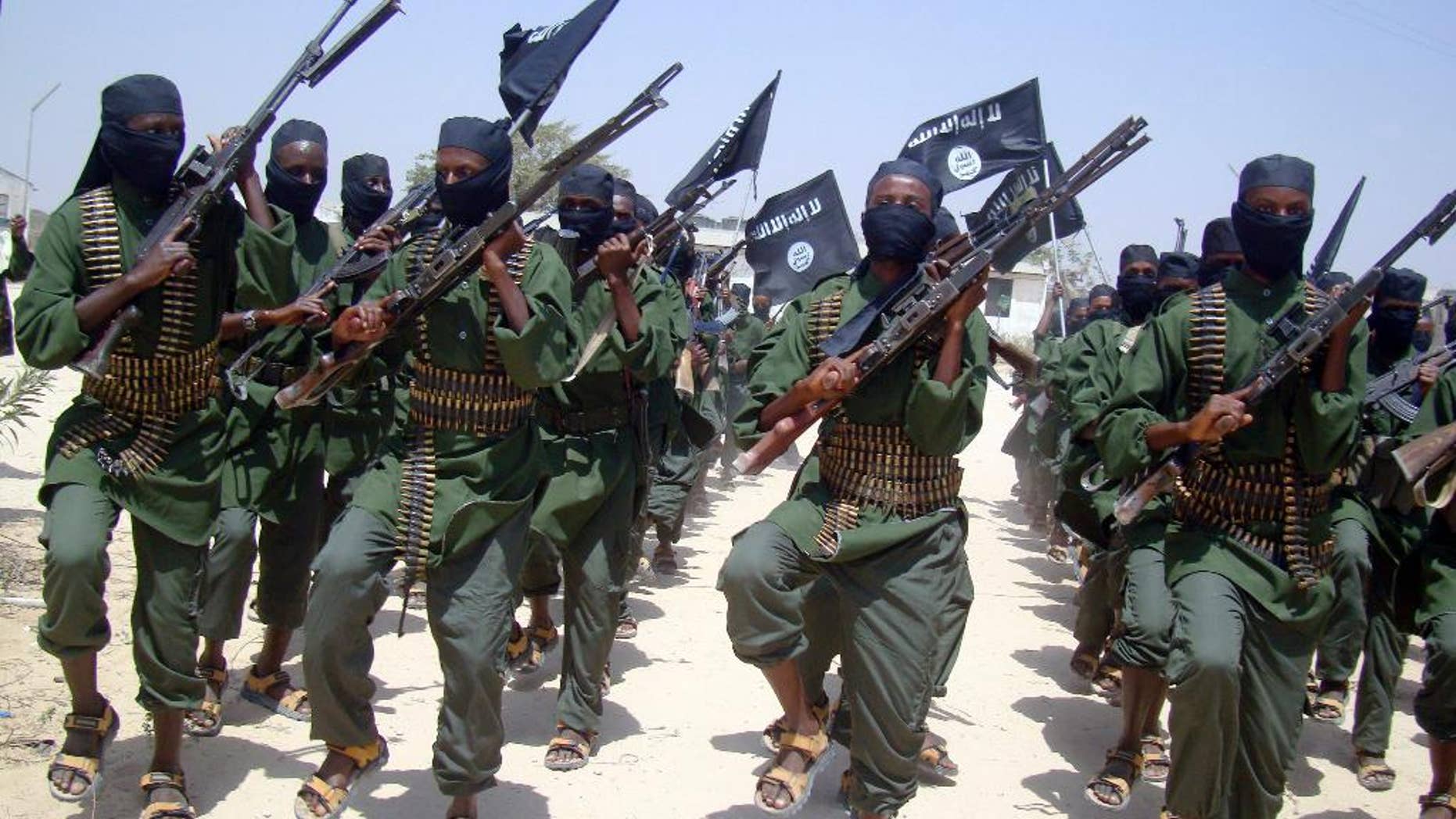 FILE - In this Thursday, Feb. 17, 2011 file photo, al-Shabab fighters march with their weapons during military exercises on the outskirts of Mogadishu, Somalia. A U.S. drone strike in Somalia has targeted a key leader of the al-Shabab militant group who was involved in two attacks in Mogadishu more than a year ago that killed more than 30 people, at least three Americans among them, the Pentagon said Friday, April 1, 2016. Several U.S. officials said he and two others were killed. Hassan Ali Dhoore was targeted in the airstrike Thursday, but the U.S. military was still assessing the results, Pentagon spokesman Peter Cook said in a statement. (AP Photo/Mohamed Sheikh Nor, File)