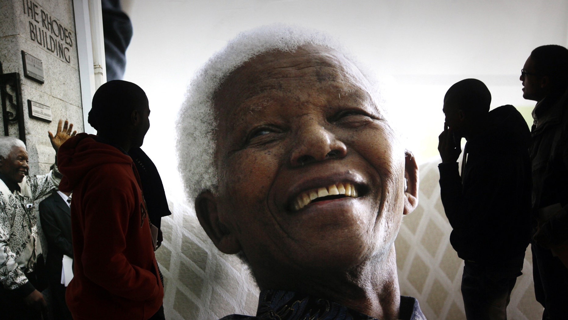 FILE - In this June 27, 2013 file photo, large photographs of former South African President Nelson Mandela are displayed at the Nelson Mandela Legacy Exhibition at the Civic Centre in Cape Town, South Africa. The "father of the nation" has inspired many artists to create works to commemorate Nelson Mandela International Day on Thursday, July 18, 2013 declared by the United Nations as a way to recognize the Nobel Prize winner's contribution to reconciliation. On Thursday, Dec. 5, 2013, Mandela died at the age of 95. (AP Photo/File)