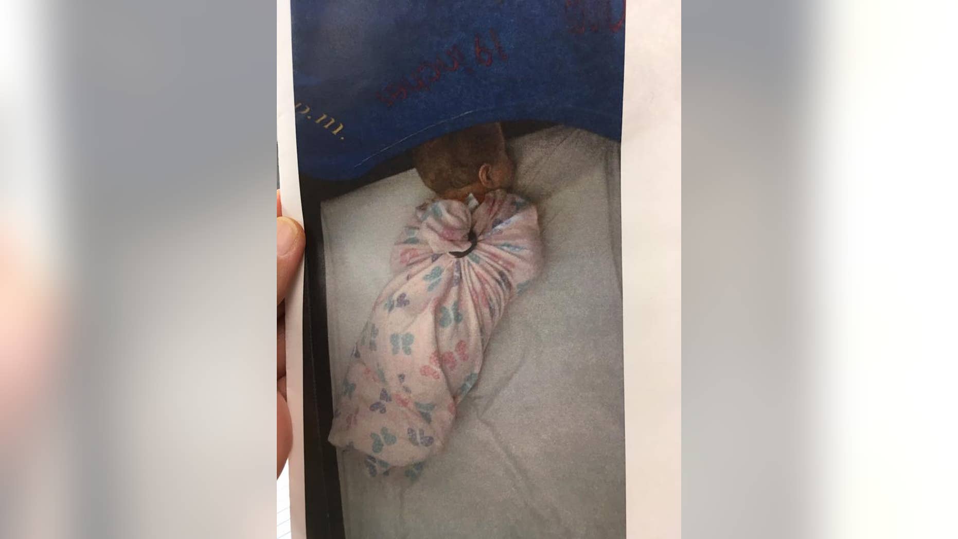 A photo obtained by the Kansas Department for Children and Families shows a baby "tied down" in a sleep sack at a day care facility in Leavenworth.