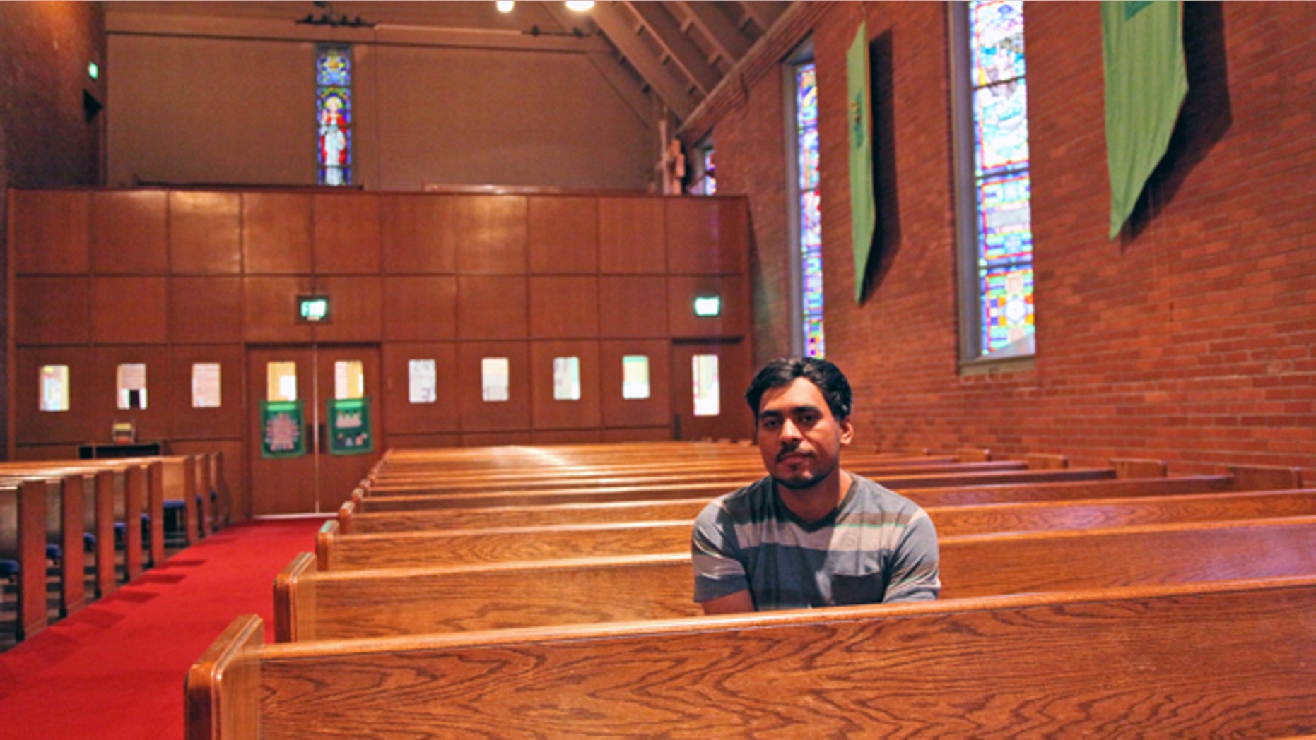 Francisco Aguirre - a community activist who first came to the U.S. from El Salvador two decades ago - poses for a photo on Sept. 24, 2014, in the church where he has taken refuge nearly a week ago to avoid deportation. Aguirre, who has two U.S. citizen children, is facing removal to his native country due to an old drug trafficking conviction and a previous deportation. (AP Photo/Gosia Wozniacka)