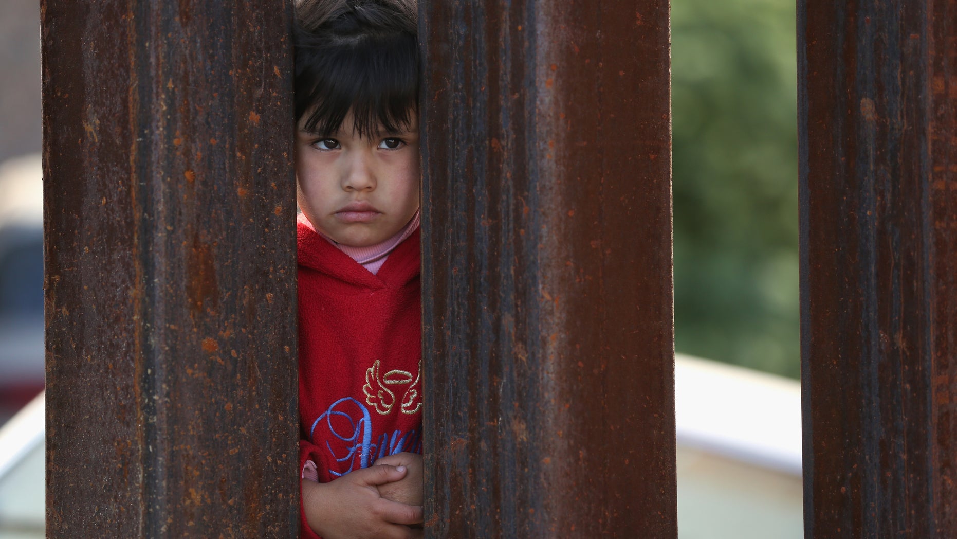 NOGALES, AZ - APRIL 01: A child on the Mexican side of the U.S.-Mexico border fence looks into Arizona during a special 'Mass on the Border' on April 1, 2014 in Nogales, Arizona. Catholic bishops led by the Archbishop of Boston Cardinal Sean O'Malley held the mass at the border fence to pray for comprehensive immigration reform and for those who have died along the border. (Photo by John Moore/Getty Images)