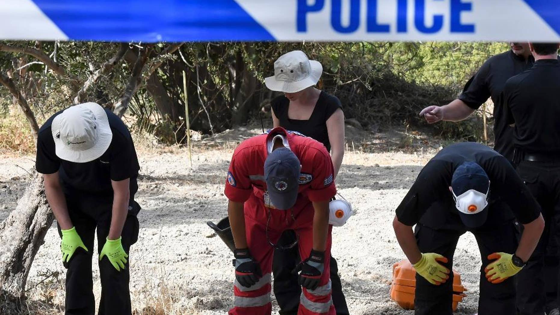 FILE - In this Monday, Sept. 26, 2016 file photo, British officers and members of the Greek rescue team search an area of land on the southeastern Greek island of Kos. A British toddler who went missing on a Greek island 25 years ago is believed to have been killed in a construction-site accident that was covered up for almost a quarter of a century, police said Monday, Oct. 17, 2016. (Nikos Panagiotopoulos/InTime News via AP, file)