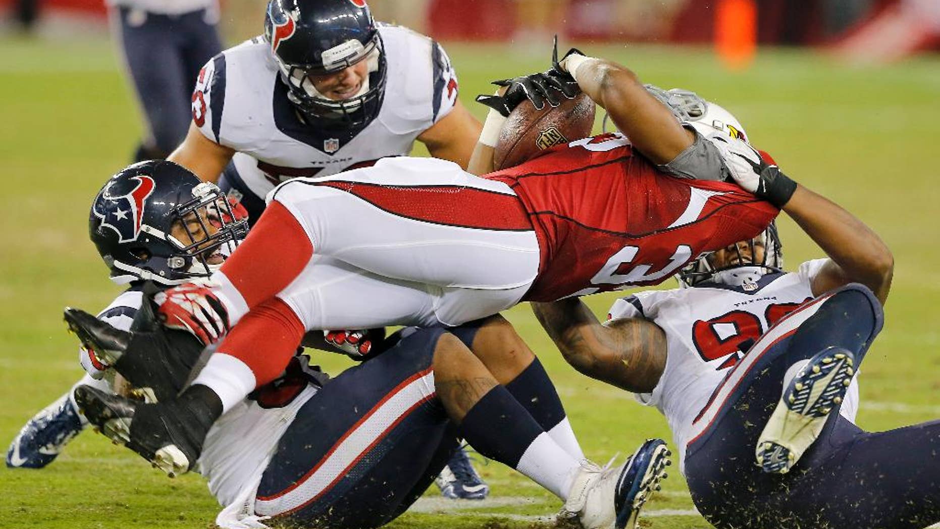 Arizona Cardinals running back Zach Bauman, center, is tackled by Houston Texans' Keith Browner, right, Max Bullough, rear, and Bronson Irwin, left, during the second half of an NFL preseason football game, Saturday, Aug. 9, 2014, in Glendale, Ariz. The Cardinals won 32-0. (AP Photo/Rick Scuteri)