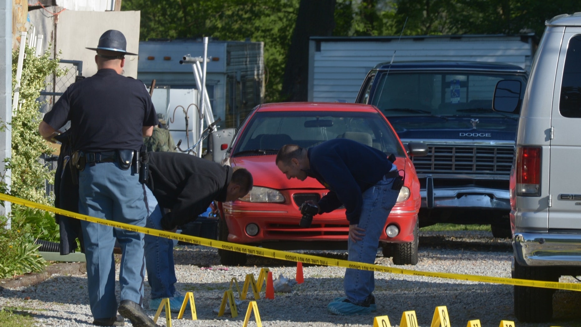 Investigators comb the area in and around 2634 Main Cross Street in Waynesville, Ind., Sunday, May 12, 2012, the scene of a quadruple homicide overnight. (AP Photo/The Republic, Joe Harpring)