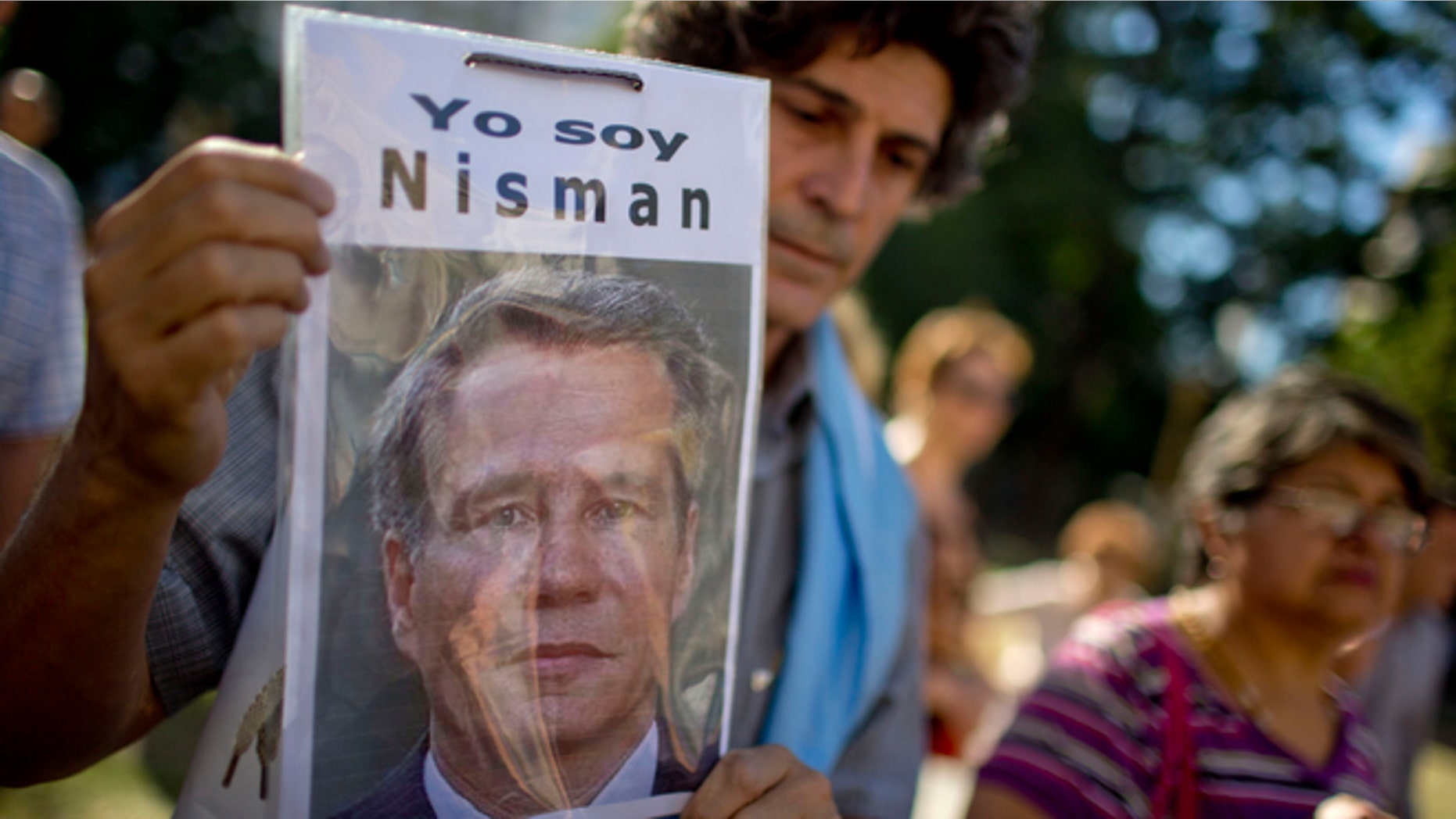 A demonstrator holds a photo of late prosecutor Alberto Nisman that reads in Spanish "I am Nisman" during an protest to demand justice after more than one month since his death outside a court house in Buenos Aires, Argentina, Wednesday, March 18, 2015. Nisman was found dead in his bathroom on January 18, on the eve of congressional hearings where he was due to present his accusations against President Cristina Fernandez of shielding Iranian officials from prosecution over the 1994 bombing of a Buenos Aires Jewish center. (AP Photo/Natacha Pisarenko)