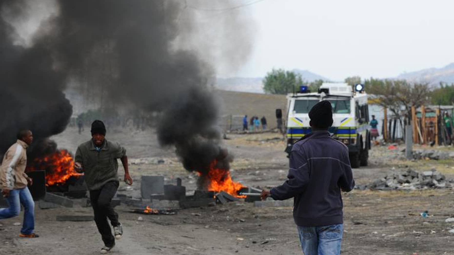 Striking miners flee South African police in Marikana on September 15, 2012 at Lonmin's platinum mine