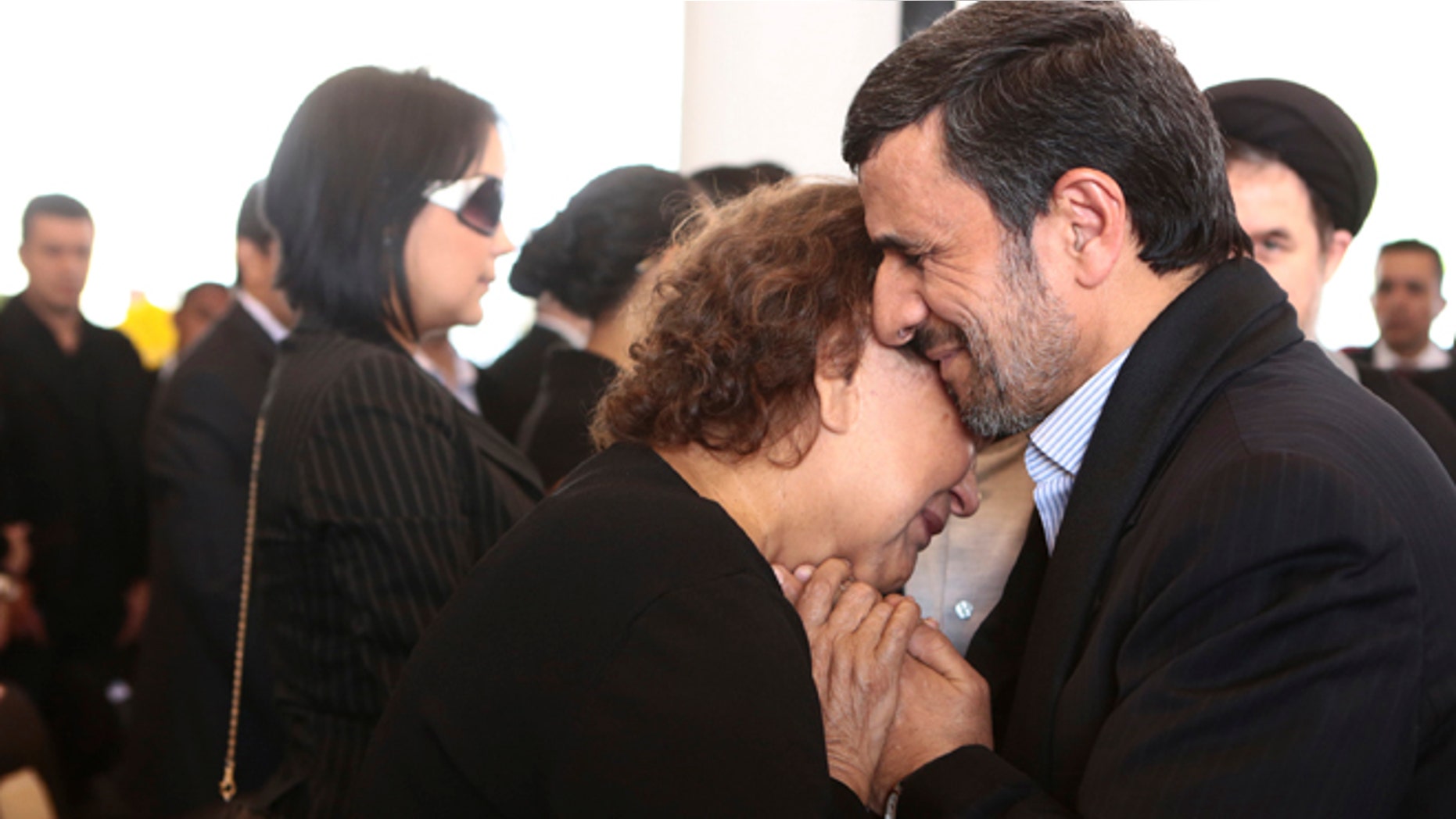 FILE --In this Friday, March 8, 2013 file photo released by the Miraflores Press Office, Iran's President Mahmoud Ahmadinejad comforts Elena Frias next to the flag-draped coffin of her son, Venezuela's late President Hugo Chavez, during the funeral ceremony at the military academy in Caracas, Venezuela.