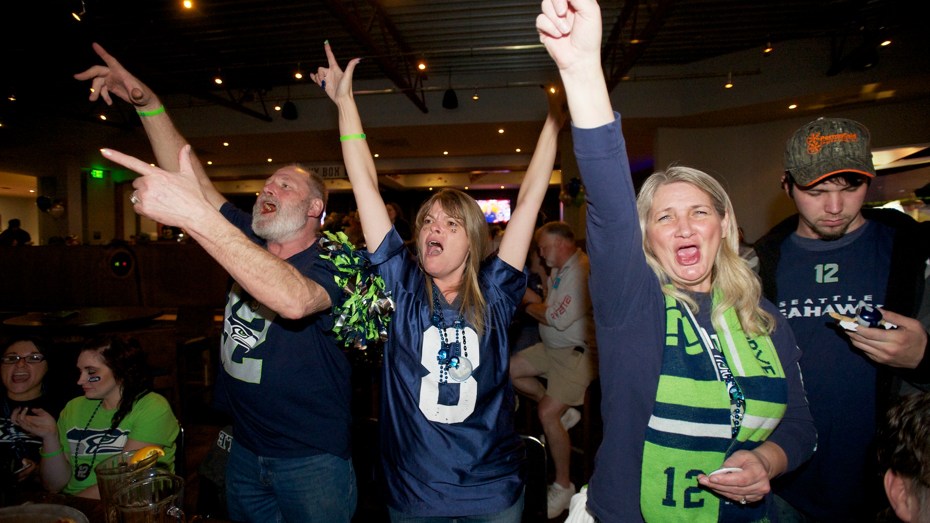 Seahawks fans from left, Ron Taylor, Michelle Taylor and Vienna Creighton celebrate while watching Super Bowl XLVIII at Big Al's in Vancouver, Wash., Sunday, Feb. 2, 2014. Seattle defeated the Denver Broncos 43-8. (AP Photo/The Columbian, Steven Lane)