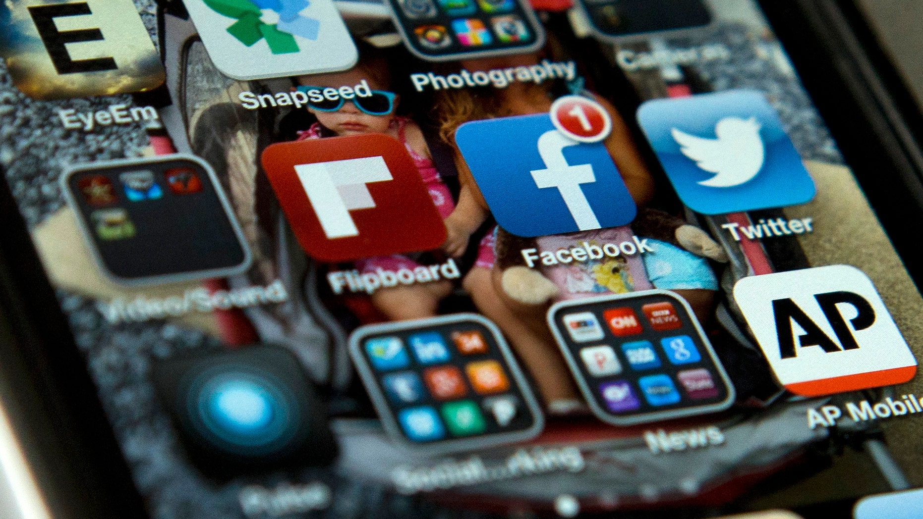 A view of an iPhone in Washington Tuesday, May 21, 2013, showing the Twitter and Facebook apps among others. A new poll finds that teens are sharing more about themselves on social media. Theyre also moving increasingly to Twitter to avoid their parents and the "oversharing" that they see on Facebook. (AP Photo/Evan Vucci)