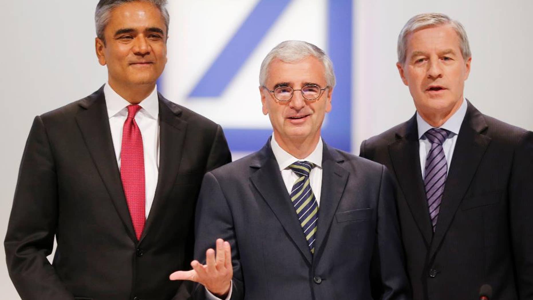 FILE - In this May 22, 2014 file photo Co-CEOs of Deutsche Bank Anshu Jain, left, and Juergen Fitschen, right, and the head of supervisory board Paul Achleitner pose for photographers at the beginning of the annual shareholders meeting in Frankfurt, Germany. Deutsche Bank said Sunday, June 7, 2015 that Jain and Fitschen will resign. John Cryan will succeed Jain in July 2015 and will become the sole CEO in May 2016. (AP Photo/Michael Probst, file)
