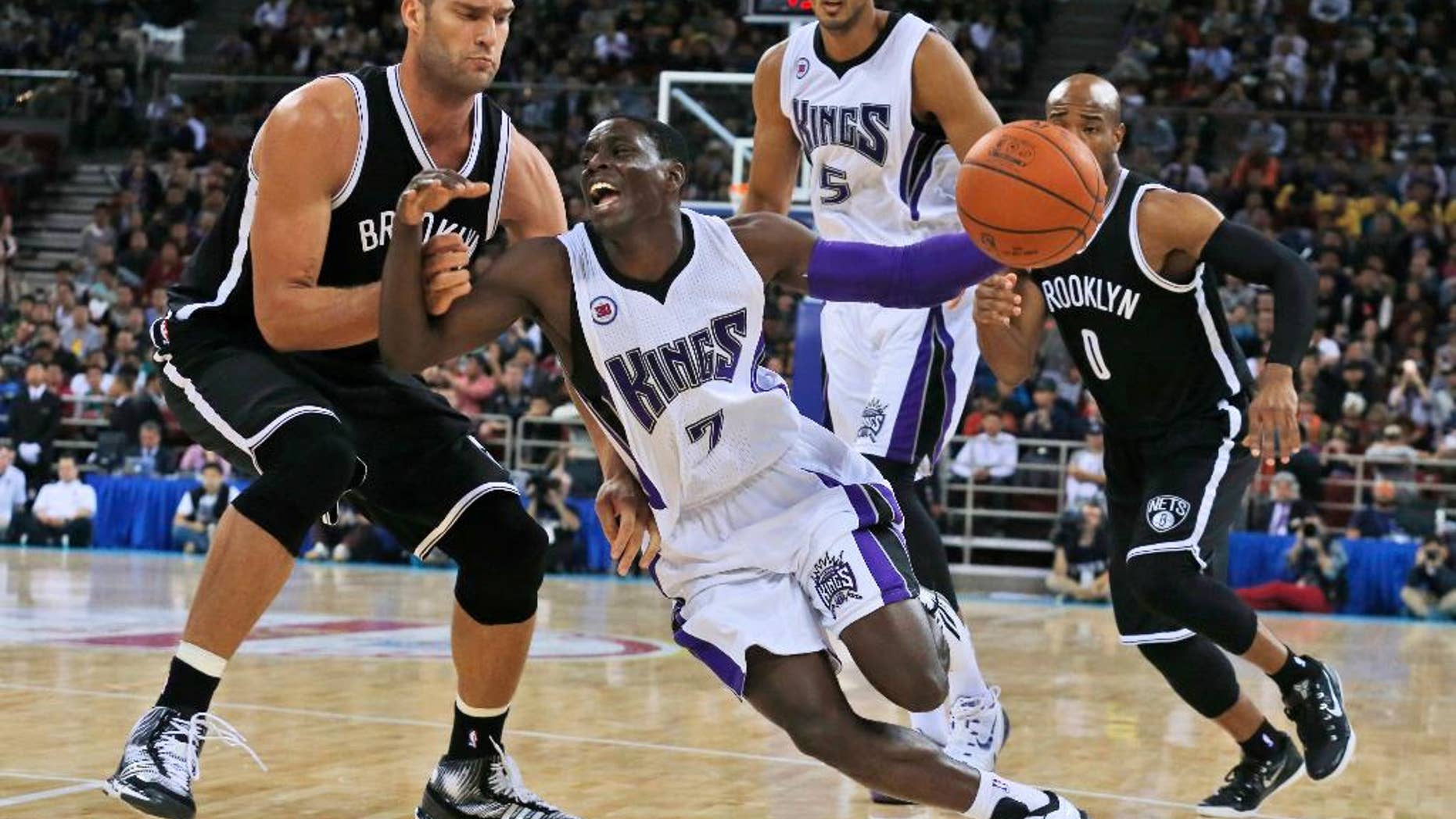 Sacramento Kings' Darren Collison, center, tries to pass Brooklyn Nets' Brook Lopez, left, during a pre-season match held in Beijing, China, Wednesday, Oct. 15, 2014. Brooklyn Nets won 129-117. (AP Photo/Ng Han Guan)