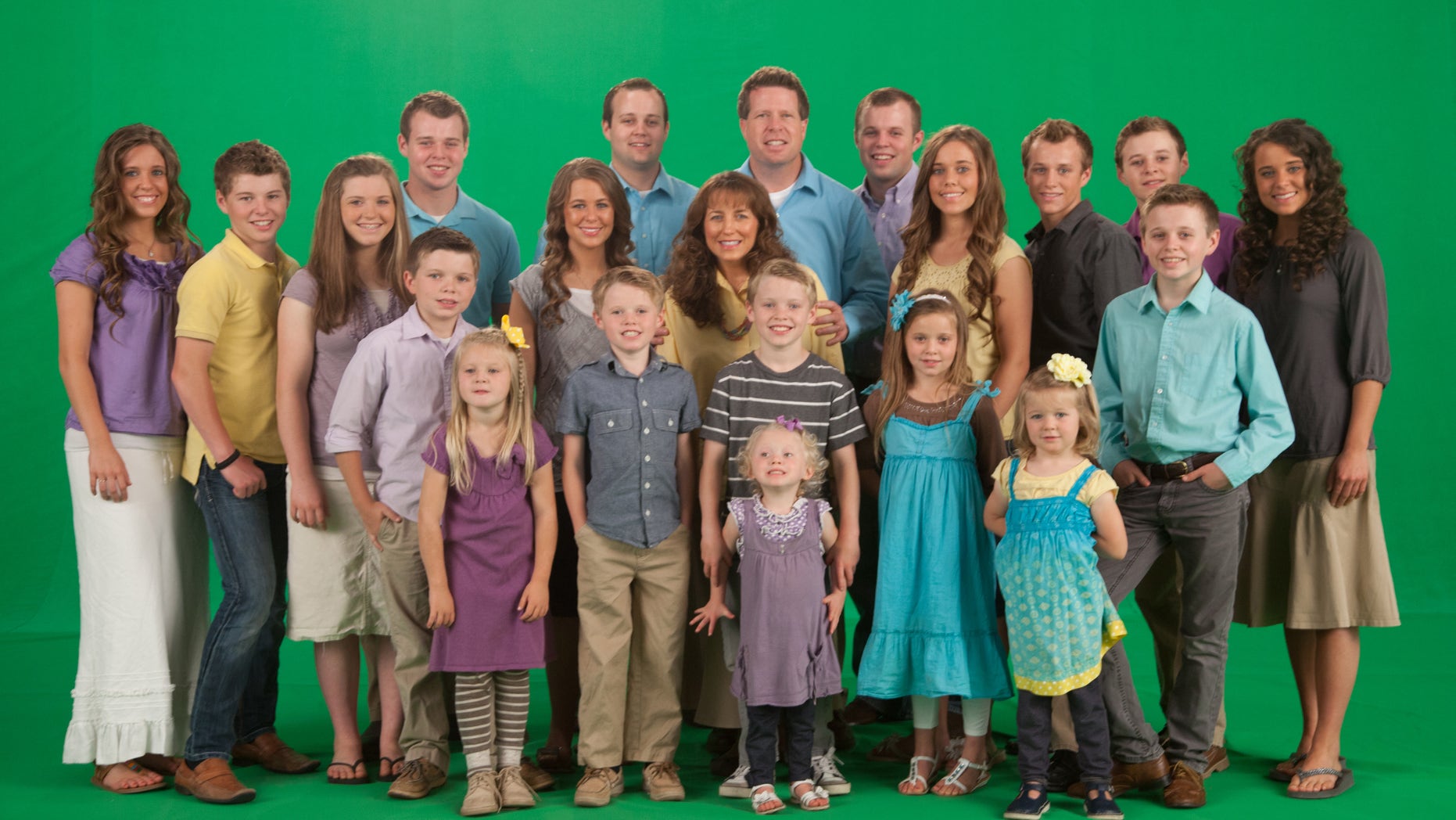 The Duggar family in front of a green screen.