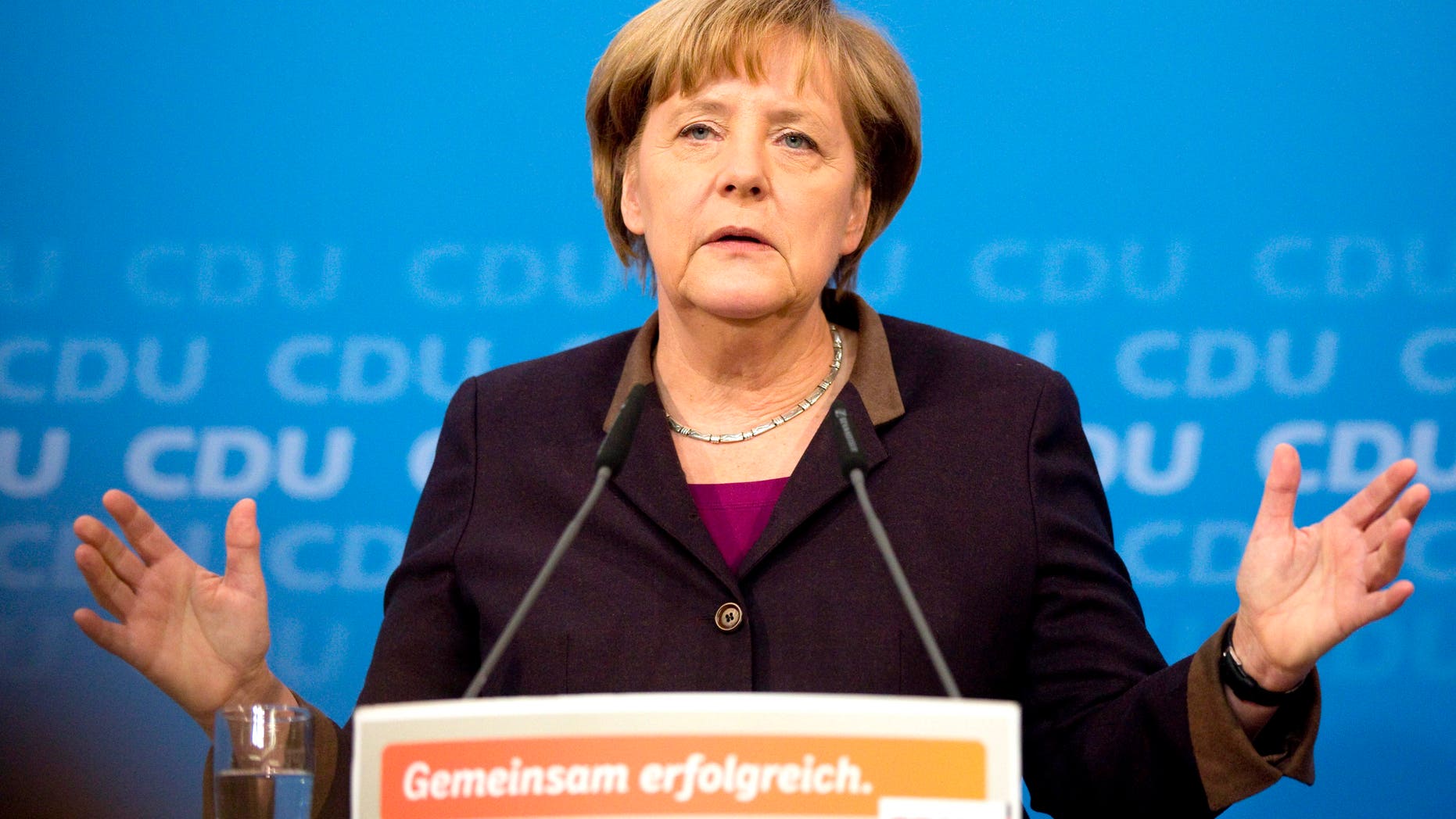 German Chancellor Angela Merkel speaks during a press conference in Berlin , Germany, Sunday Dec. 15, 2013. Germany will get its first female defense minister in Chancellor Angela Merkel's new government, while the country's influential finance minister will stay in his job. Merkel confirmed Sunday that Ursula von der Leyen, currently labor minister, will become defense chief. The 55-year-old mother of seven inherits the job of modernizing the German military and overseeing its deployment in Afghanistan. Finance Minister Wolfgang Schaeuble, Merkel's co-pilot in fighting Europe's debt crisis, will stay on. Sign reads : Together Successful. (AP Photo/Christian Thiel)