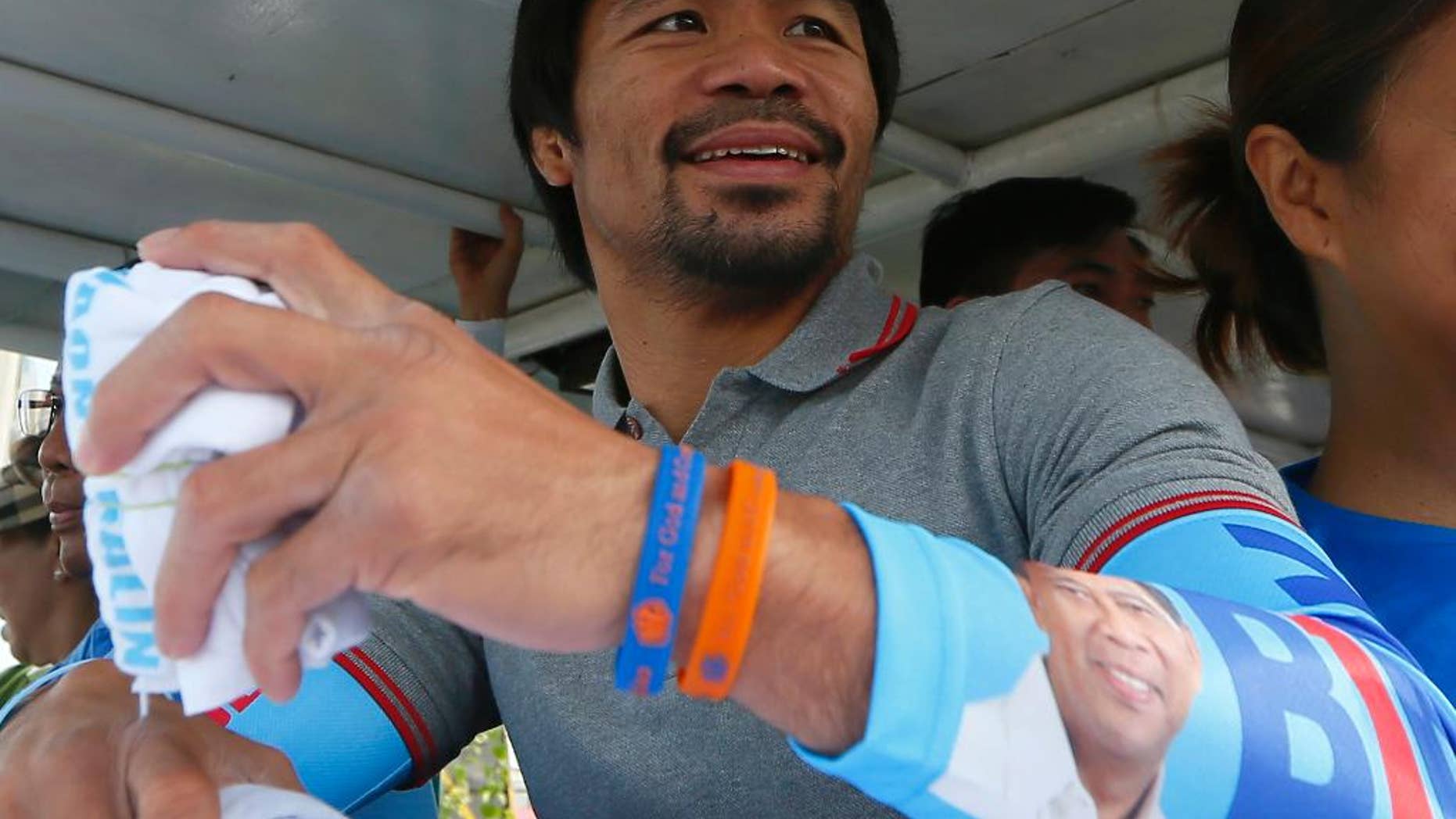 FILE - In this Friday, May 6, 2016, file photo, Congressman Manny Pacquiao, who is running for senator in the national elections, smiles from a campaign vehicle during a campaign rally in Navotas,north of Manila, Philippines. The boxing great appears to have won a seat in the Philippine Senate, according to unofficial results. Pacquiao has garnered more than 15 million votes, with about 93 percent of precincts reporting Tuesday, May 10, 2016. (AP Photo/Bullit Marquez, File)