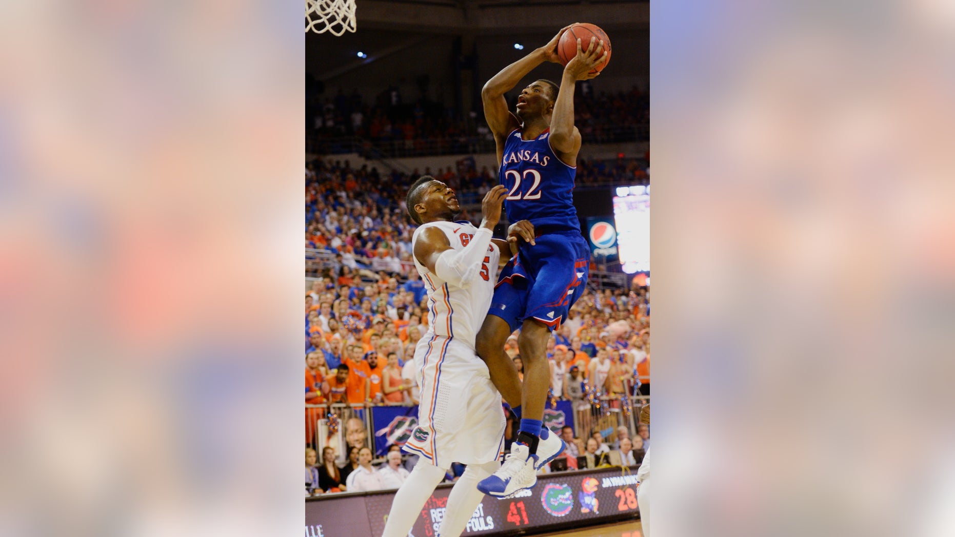 Kansas guard Andrew Wiggins (22) goes for two points with Florida forward Will Yeguete (15) trying to stop the shot during the second half of an NCAA college basketball game Tuesday, Dec. 10, 2013 in Gainesville, Fla. Florida defeated the University of Kansas 67-61. (AP Photo/Phil Sandlin)