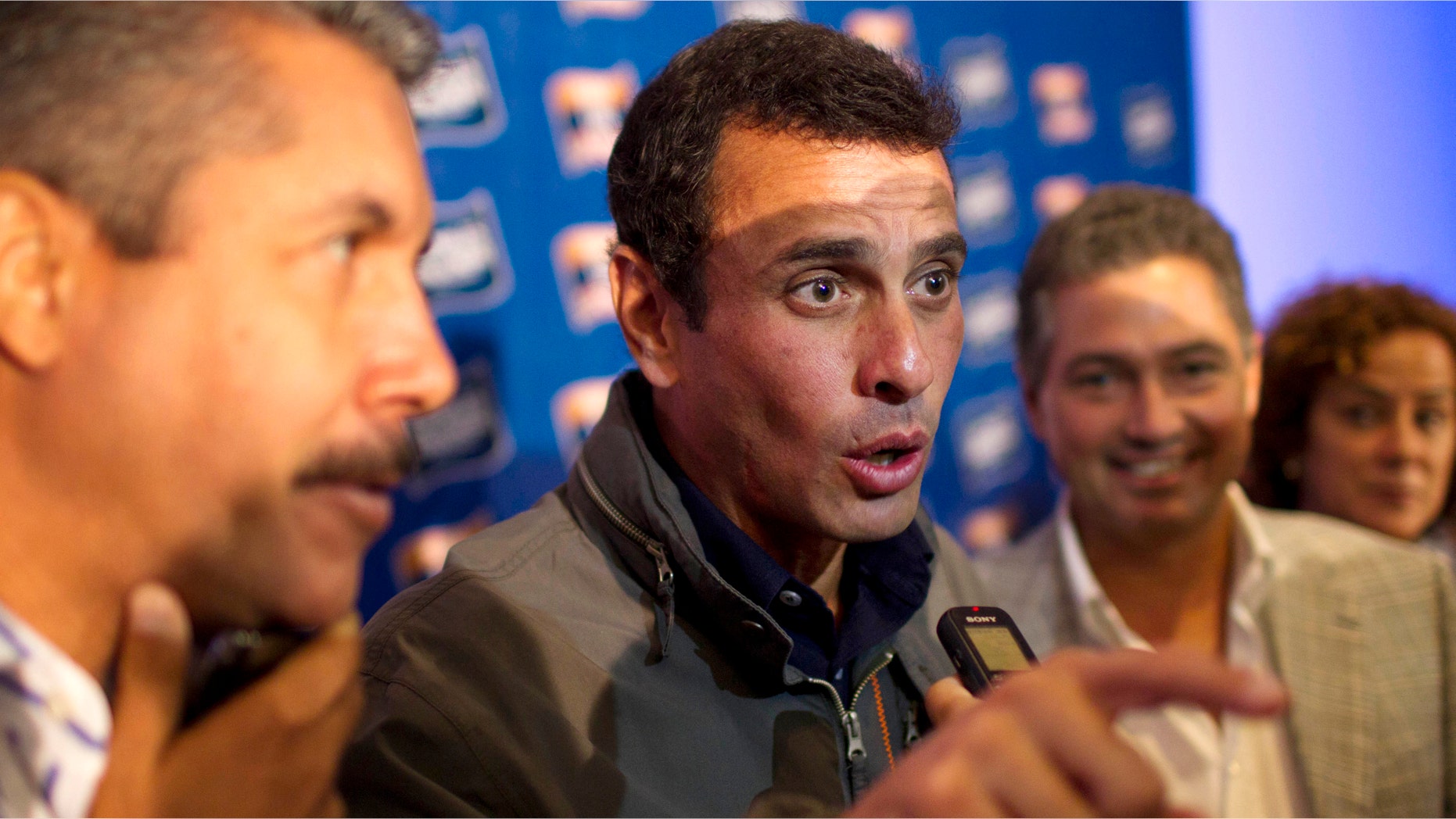 Opposition leader Henrique Capriles, center, speaks to the press. (AP Photo/Ariana Cubillos)