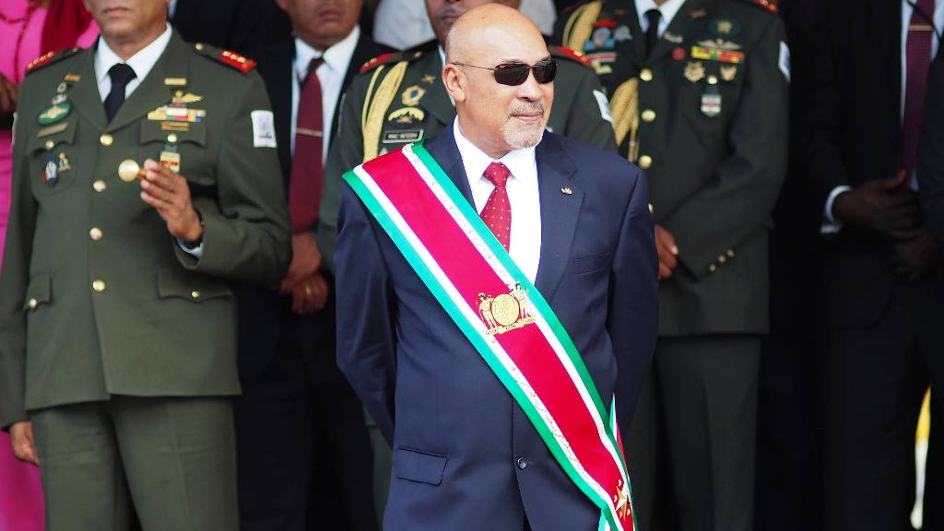 FILE - In this Aug. 12, 2015 file photo, Suriname President Desire Delano Bouterse observes a military parade, after being sworn in for his second term, in Paramaribo, Suriname. A military court in Suriname on Monday, Jan. 30, 2017, ordered the president to resume his long-stalled murder trial in the killing of political opponents under his dictatorship in 1982. (AP Photo/Ertugrul Kilic, File)