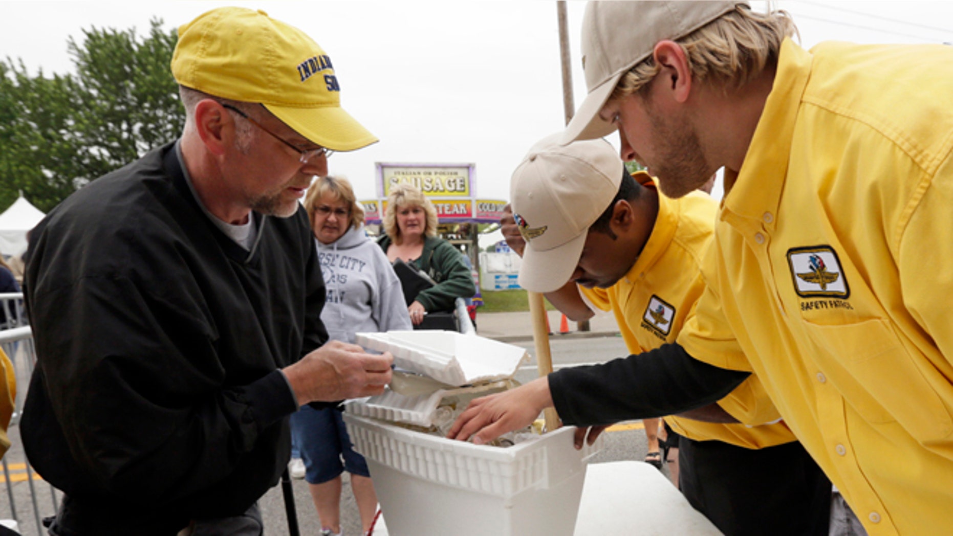 Indianapolis Motor Speedway Safety Patrol members inspect a patron's cooler as he enters the track for the Indianapolis 500 auto race in Indianapolis, Sunday, May 26, 2013. (AP Photo/AJ Mast)