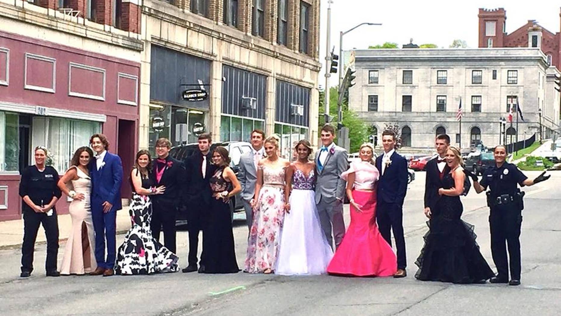 Two officers with Maine's Bangor Police Department posed for a prom photo with high school students after they were reported to police for blocking the street.