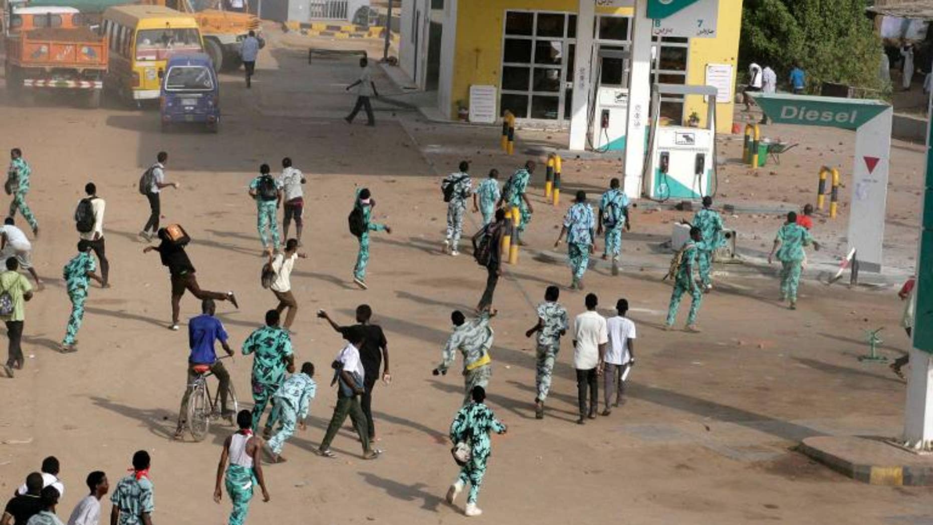 Sudanese protestors throw stones at a petrol station in Khartoum's twin city of Omdurman during a demonstration after the government announced steep price rises for petroleum products on September 25, 2013
