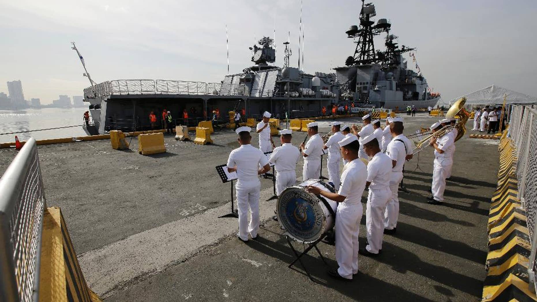 A Philippines Navy Band plays as the Russian Navy vessel Admiral Tributs, a large anti-submarine ship, docks at Manila's pier on Tuesday.