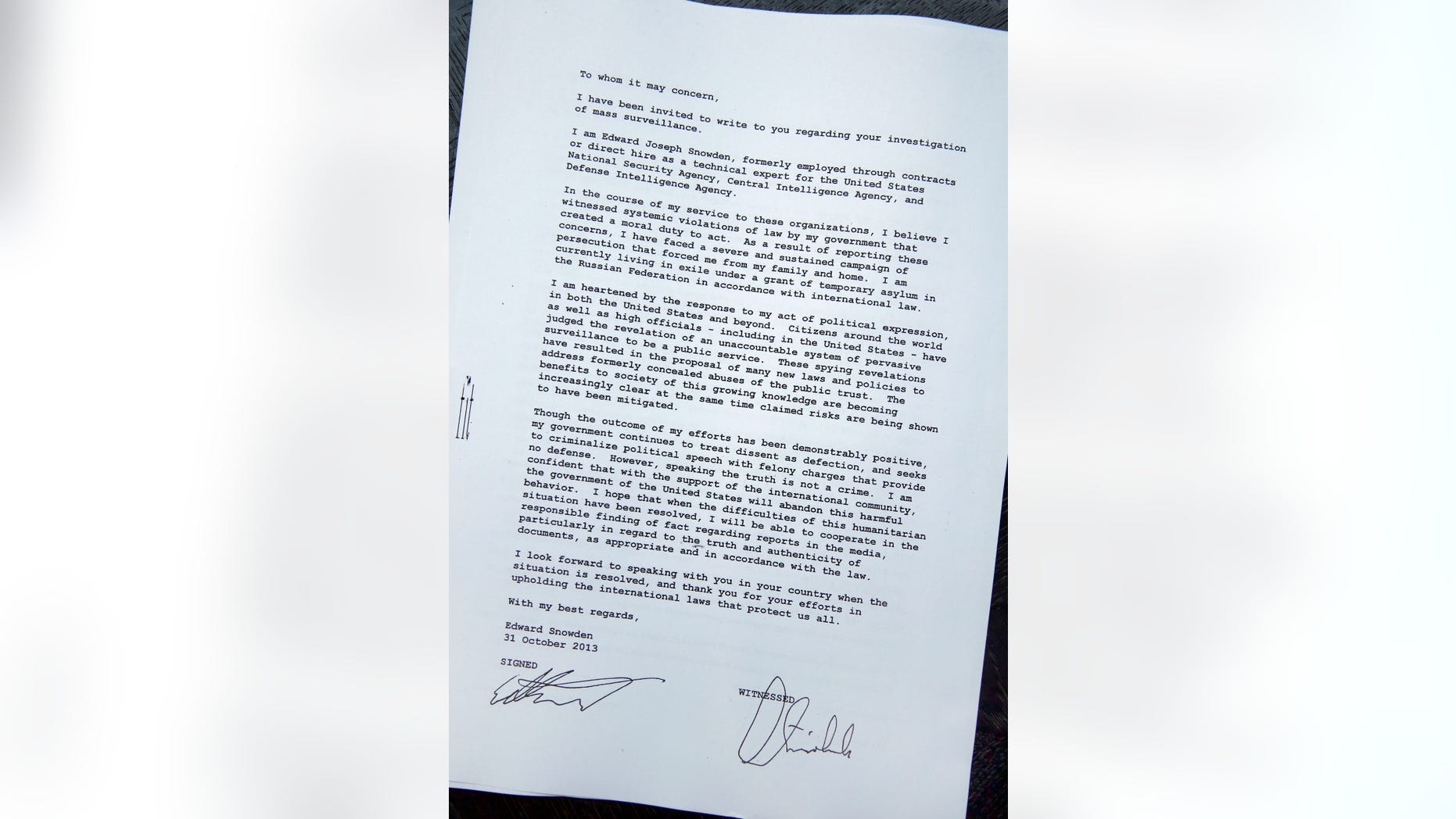 Opposition Greens lawmaker Hans-Christian Stroebele, shows a copy of a a letter to the media, he claims he received from Edward Snowden, prior to a press conference in Berlin, Germany, Friday, Nov. 1, 2013. Stroebele said he met Edward Snowden in Moscow on Thursday, and that the National Security Agency leaker is prepared to help Germany investigate allegations of surveillance by U.S. intelligence. Snowden was granted asylum in Russia in August after being stuck at a Moscow airport for more than a month following his arrival there from Hong Kong. The 30-year-old faces espionage charges in the U.S. (AP Photo/Michael Sohn)