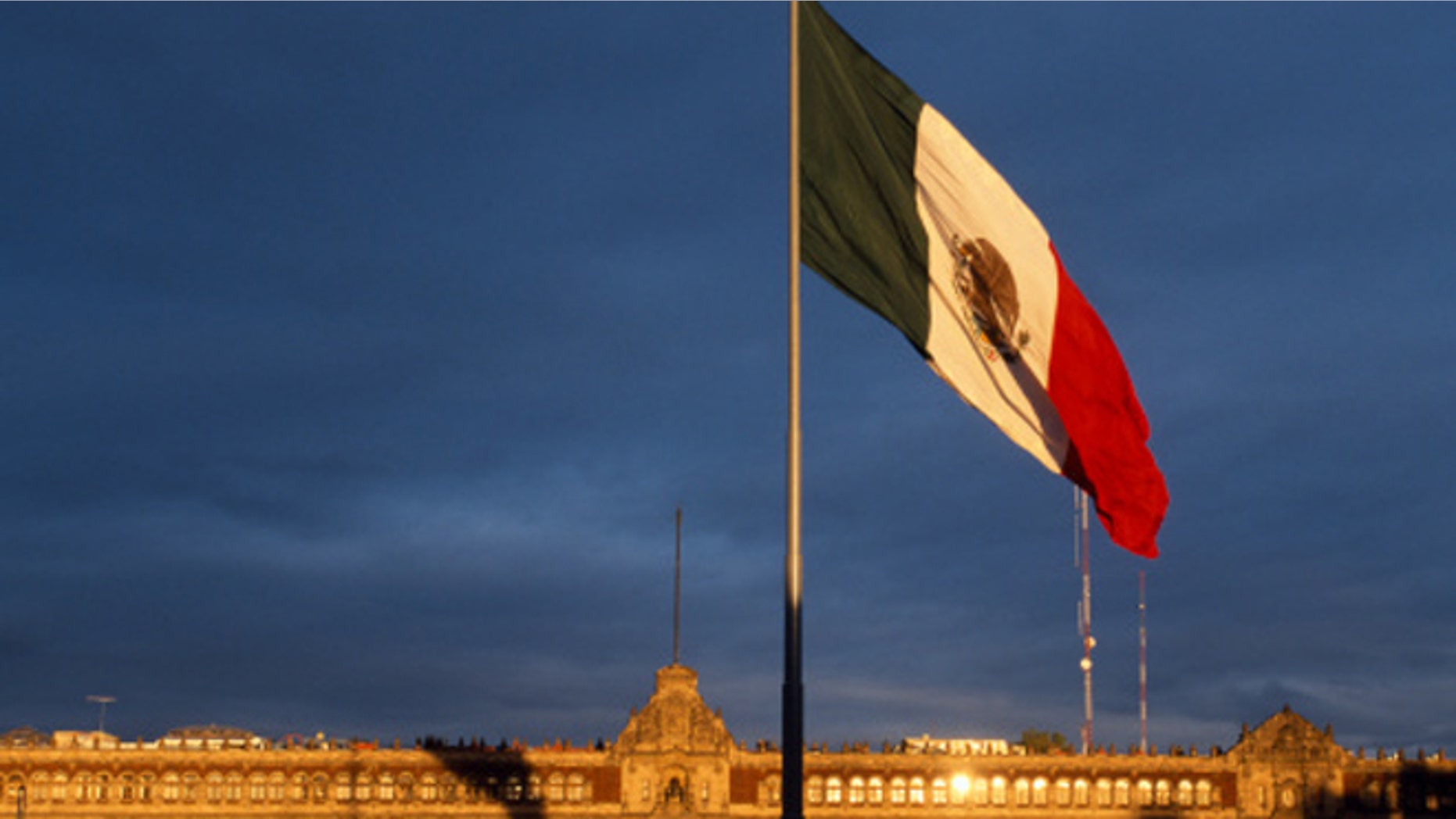 Mexico, Mexico City. Giant Mexican flag in the Zocala Squarewith the National Palace behind.