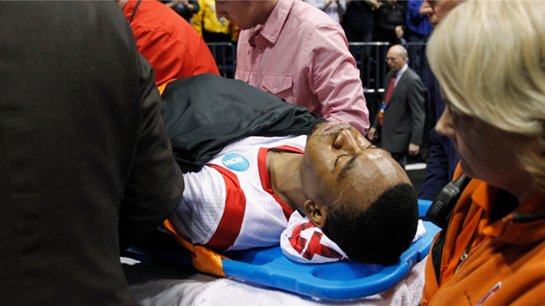 Louisville guard Kevin Ware is taken off of the court on a stretcher after his injury during the first half of the Midwest Regional final against Duke in the NCAA college basketball tournament Sunday March 31, 2013, in Indianapolis. (AP Photo/Darron Cummings)