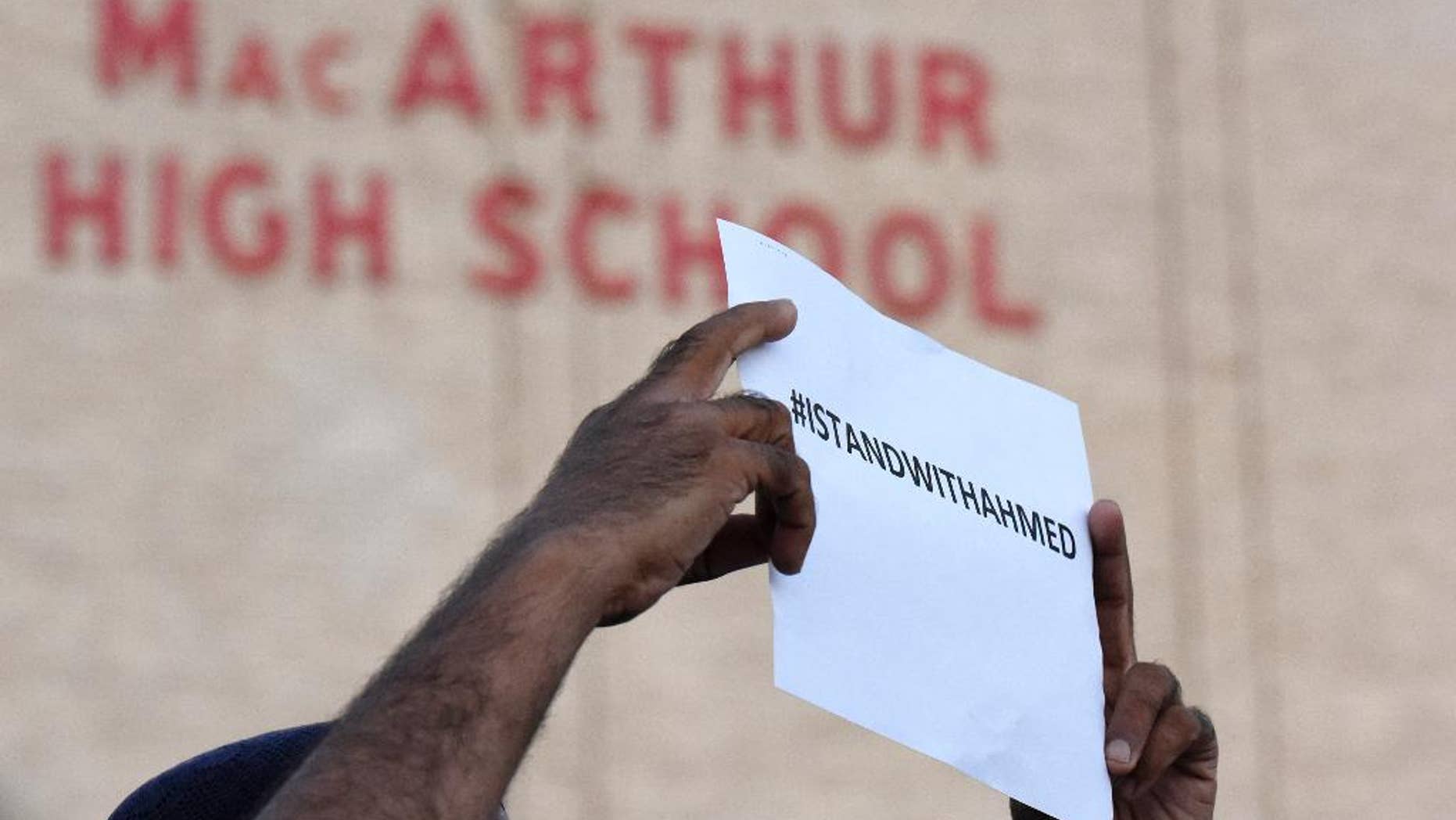 A sign supporting Ahmed Mohamed is held up in front of MacArthur High School at a prayer vigil, Thursday, Sept. 17, 2015, in Irving, Texas. Ahmed, 14, was arrested Monday when a clock he built and brought to school was mistaken for a bomb by teachers and police. (AP Photo/Jeffrey McWhorter).