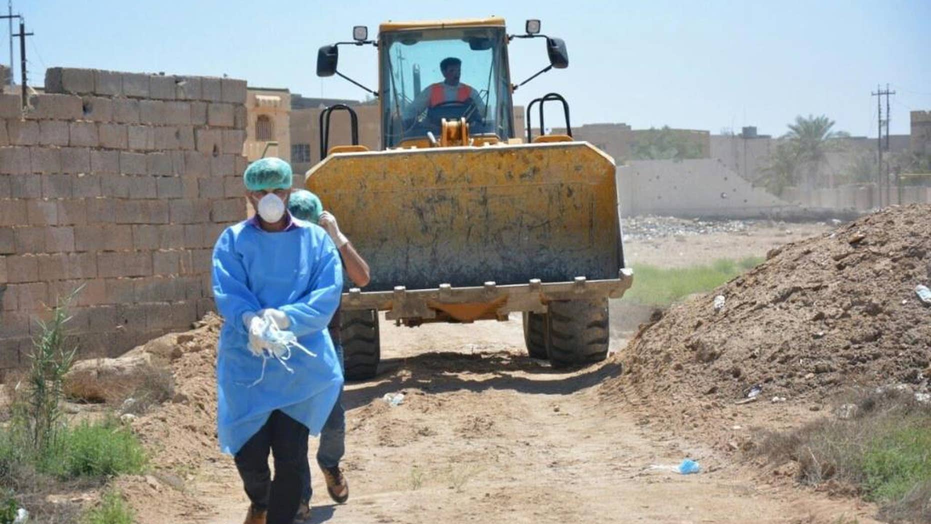 An Iraqi security forces forensic team works at at the site of a mass grave, one of two discovered containing the bodies of dozens of men, women and children killed by Islamic State group militants, in the stadium area in Ramadi, 115 kilometers (70 miles) west of Baghdad, Iraq, Tuesday, April 19, 2016. (AP Photo)