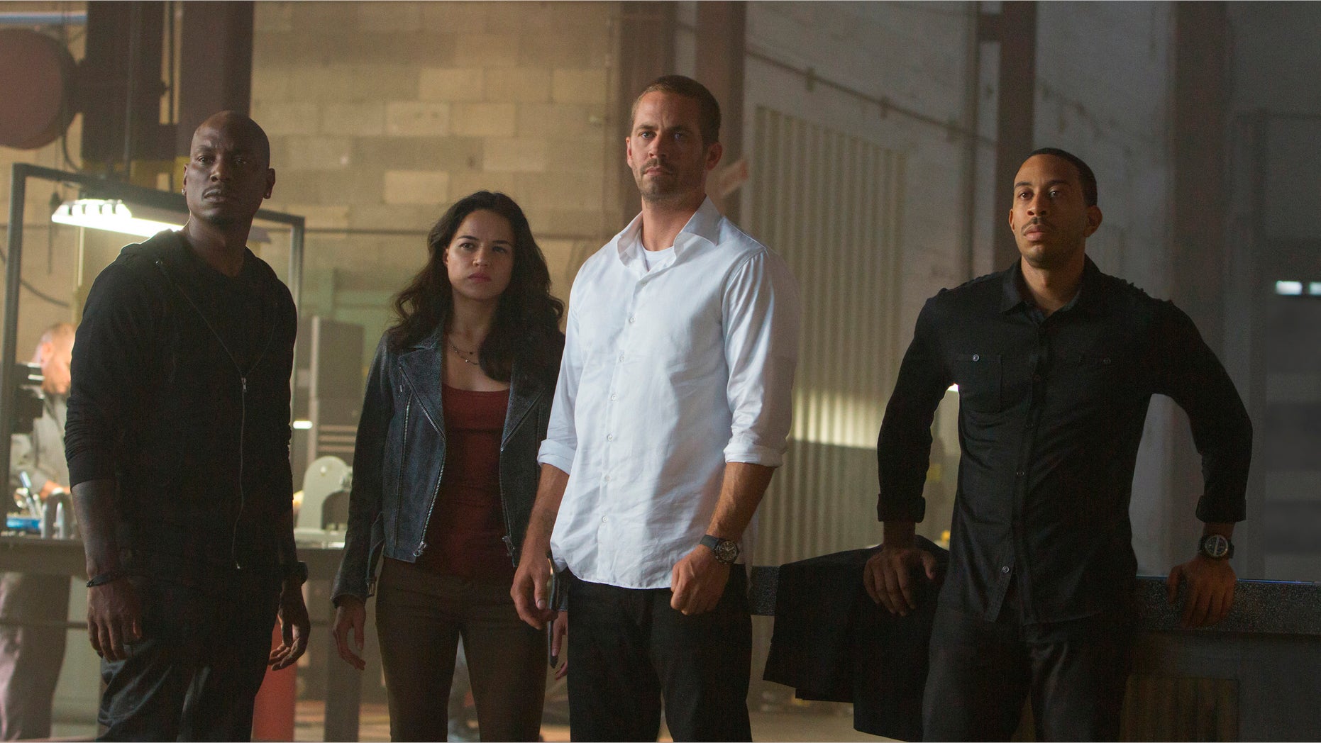 This photo provided by Universal Pictures shows, from left, Tyrese Gibson as Roman, Michelle Rodriguez as Letty, Paul Walker as Brian, and Chris Ludacris as Tej, in a scene from "Furious 7." (AP Photo/Universal Pictures, Scott Garfield)
