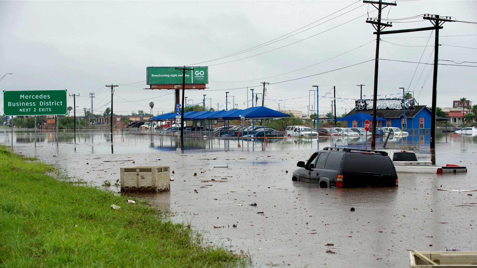 Abandoned vehicles sit in sewage-tainted floodwater Wednesday, June 20, 2018, near Mercedes, Texas.