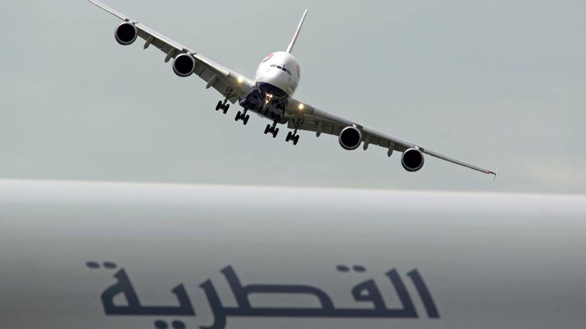 FILE- In this Tuesday June 18, 2013 file photo, a British Airways Airbus A380 prepares to land after performing its demonstration flight, at the 50th Paris Air Show at Le Bourget airport, north of Paris. A Qatar Airways Boeing Dreamliner is visible at foreground. Qatar Airways and the parent of British Airways are intensifying their relationship by setting up a revenue-sharing business partnership that will see them cooperating on scheduling and ticket prices. (AP Photo/Remy de la Mauviniere, File)