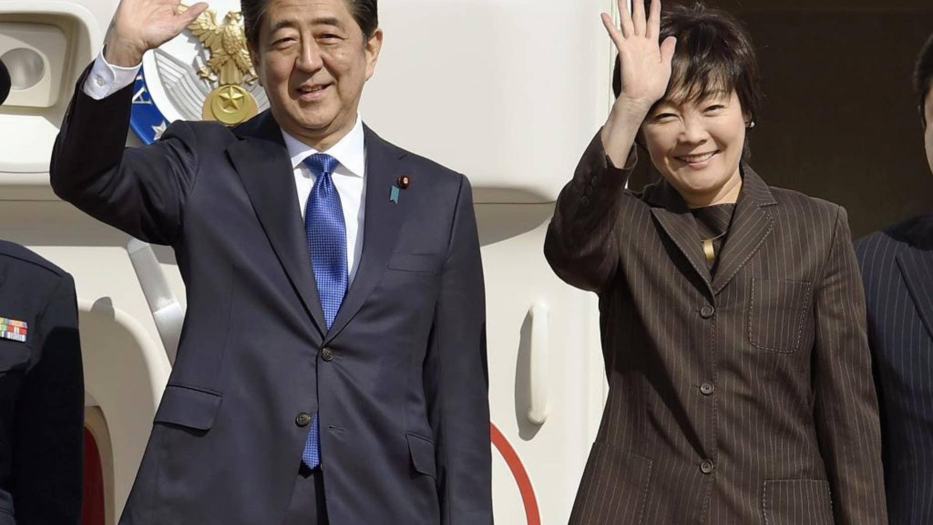 Japanese Prime Minister Shinzo Abe and his wife Akie wave prior to their departure to New York, at Haneda airport in Tokyo Thursday, Nov. 17, 2016. Abe plans to meet with President-elect Donald Trump on Thursday in New York. (Takuto Kaneko/Kyodo News via AP)