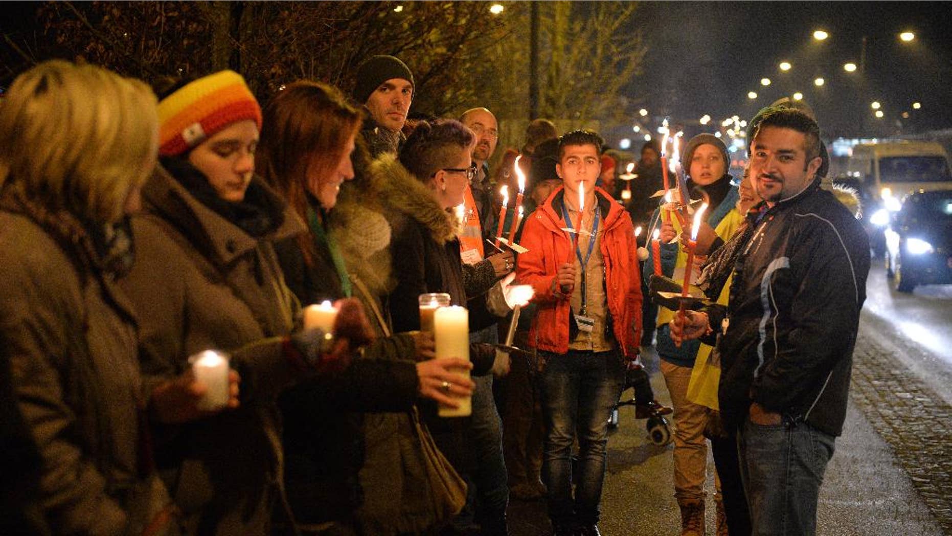 Participants with candles and torches stand on a bridge at the border between Austria and Germany during a demonstration for "Human refugee policy in a Europe without borders" in support of migrants, in Salzburg, Austria, Monday, Dec. 14, 2015. (AP Photo/Kerstin Joensson)