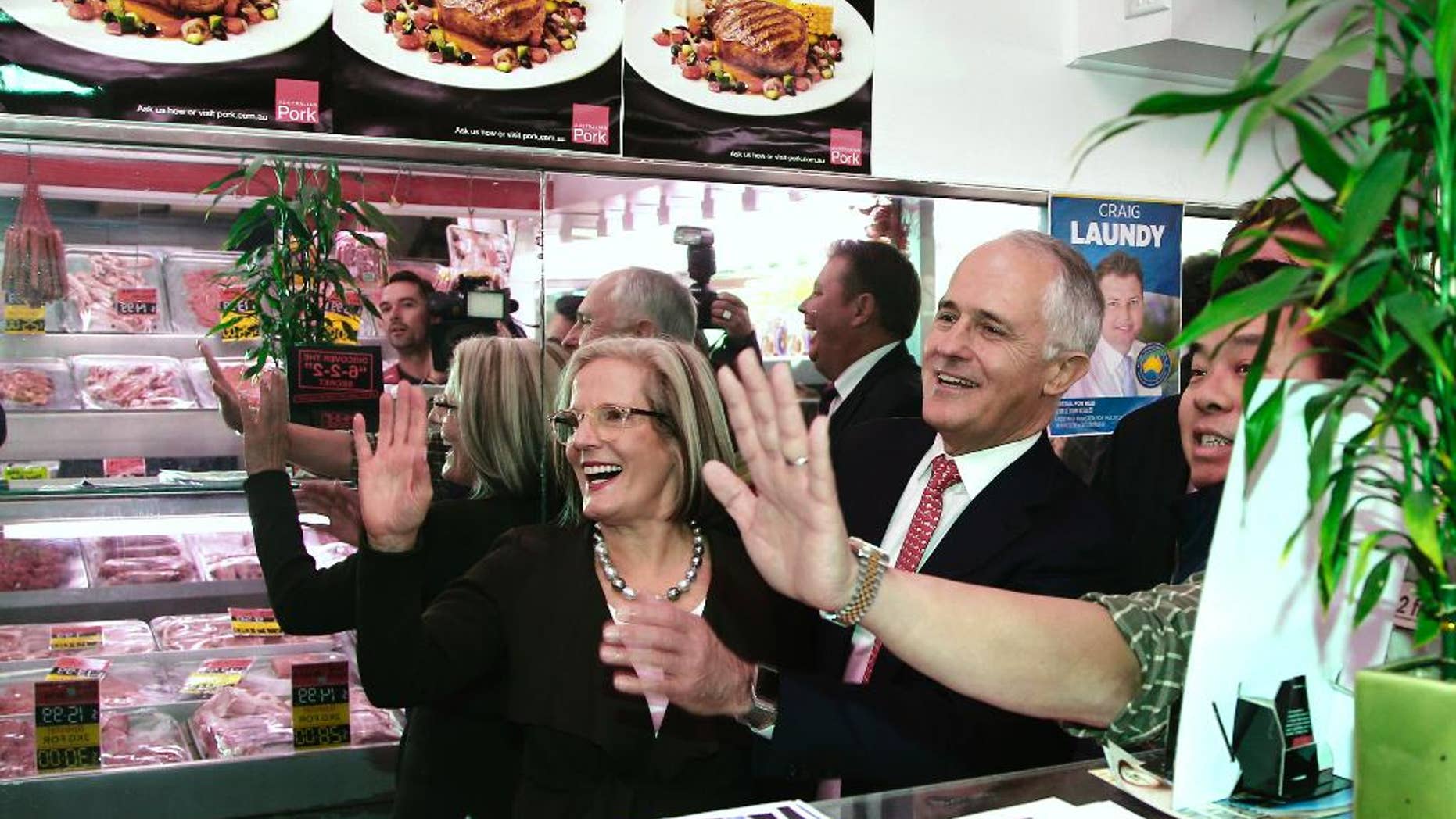 FILE - In this Friday July 1, 2016, file photo, Australia's Prime Minister Malcolm Turnbull, center, greets people in a butcher's shop during a visit to a shopping street in Burwood, Sydney, Australia. Despite being two words, democracy sausage qualified as the Australian National Dictionary Center's word for 2016 because it was essentially a compound word, the center's director Amanda Laugesen said. (AP Photo/Rob Griffith, File)