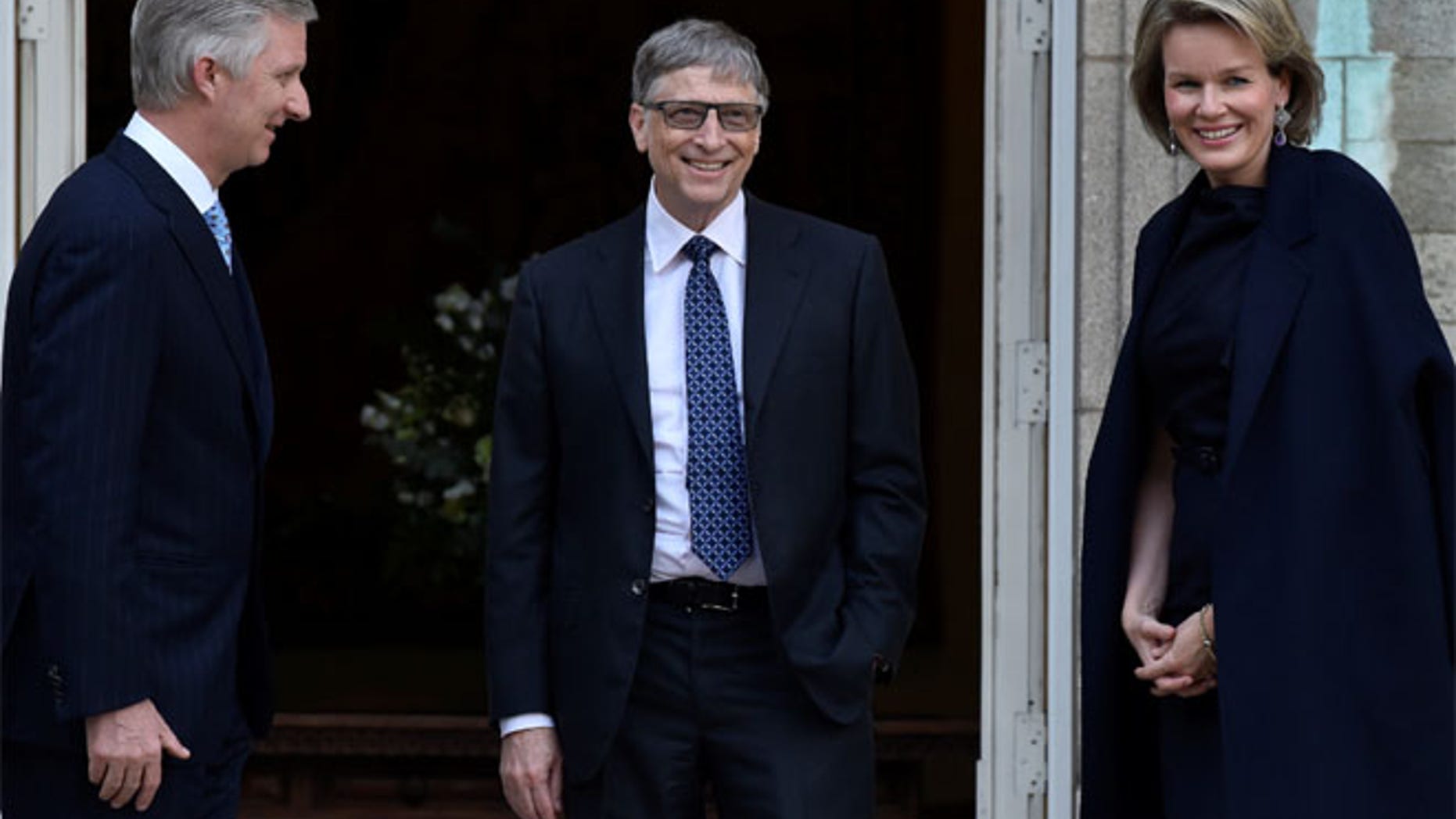Belgium's King Philippe and Queen Mathilde walk towards the photographers with Microsoft founder Bill Gates