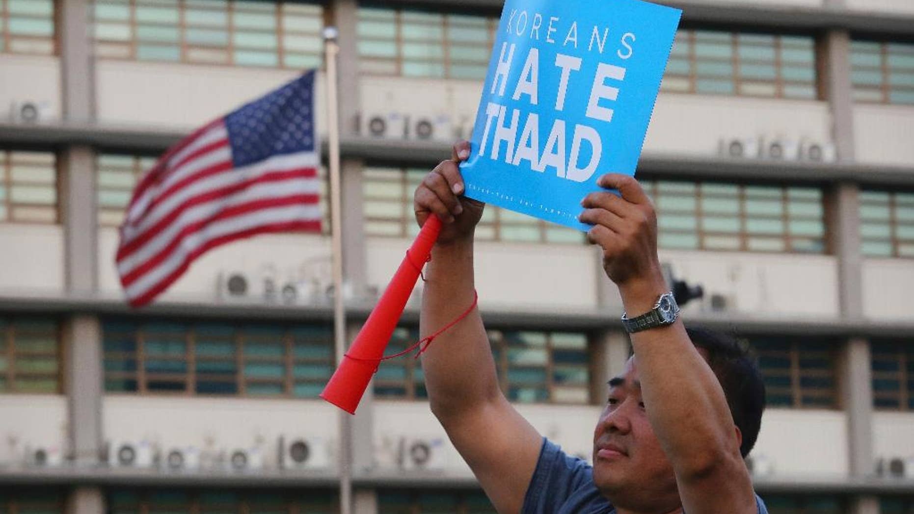 A South Korean protester holds up a card during a rally to oppose a plan to deploy the advanced U.S. missile defense system called Terminal High-Altitude Area Defense, or THAAD, near U.S. Embassy in Seoul, South Korea, Saturday, April 29, 2017. A North Korean mid-range ballistic missile apparently failed shortly after launch Saturday, South Korea and the United States said. (AP Photo/Ahn Young-joon)