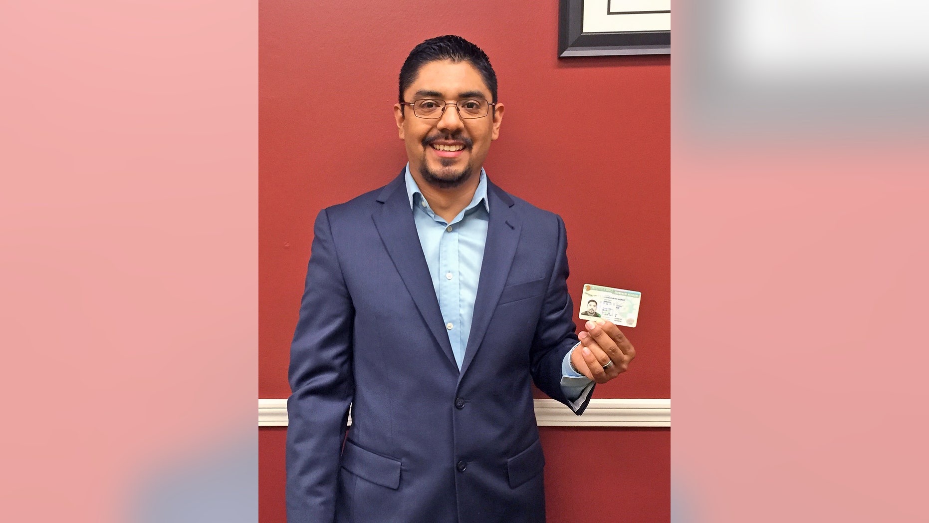 In this photo provided by Amairani Serna, lawyer Sergio Garcia holds up his green card at his law office in Chico, Calif., Thursday, June 4, 2015. Garcia, a Northern California attorney who successfully fought a high-profile battle to practice law despite his immigration status, can now live in the country legally. Sergio Garcia got his green card Thursday. That means Garcia can practice law _ and live _ in the United States without fear of arrest and deportation to his native Mexico. (Amairani Serna via AP)