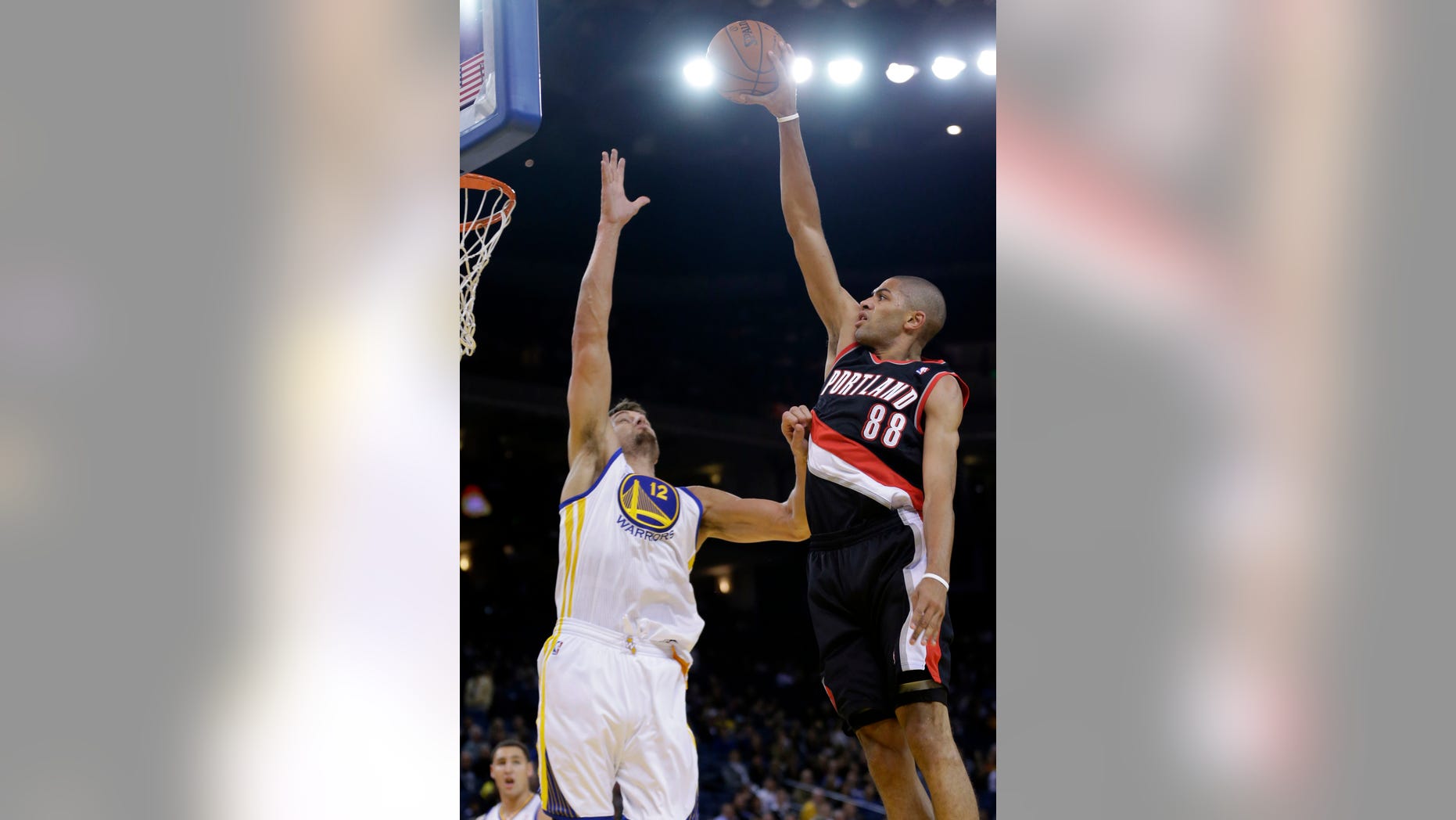 Portland Trail Blazers' Nicolas Batum (88) shoots over Golden State Warriors' Andrew Bogut during the first half of an NBA preseason basketball game on Thursday, Oct. 24, 2013, in Oakland, Calif. (AP Photo/Marcio Jose Sanchez)